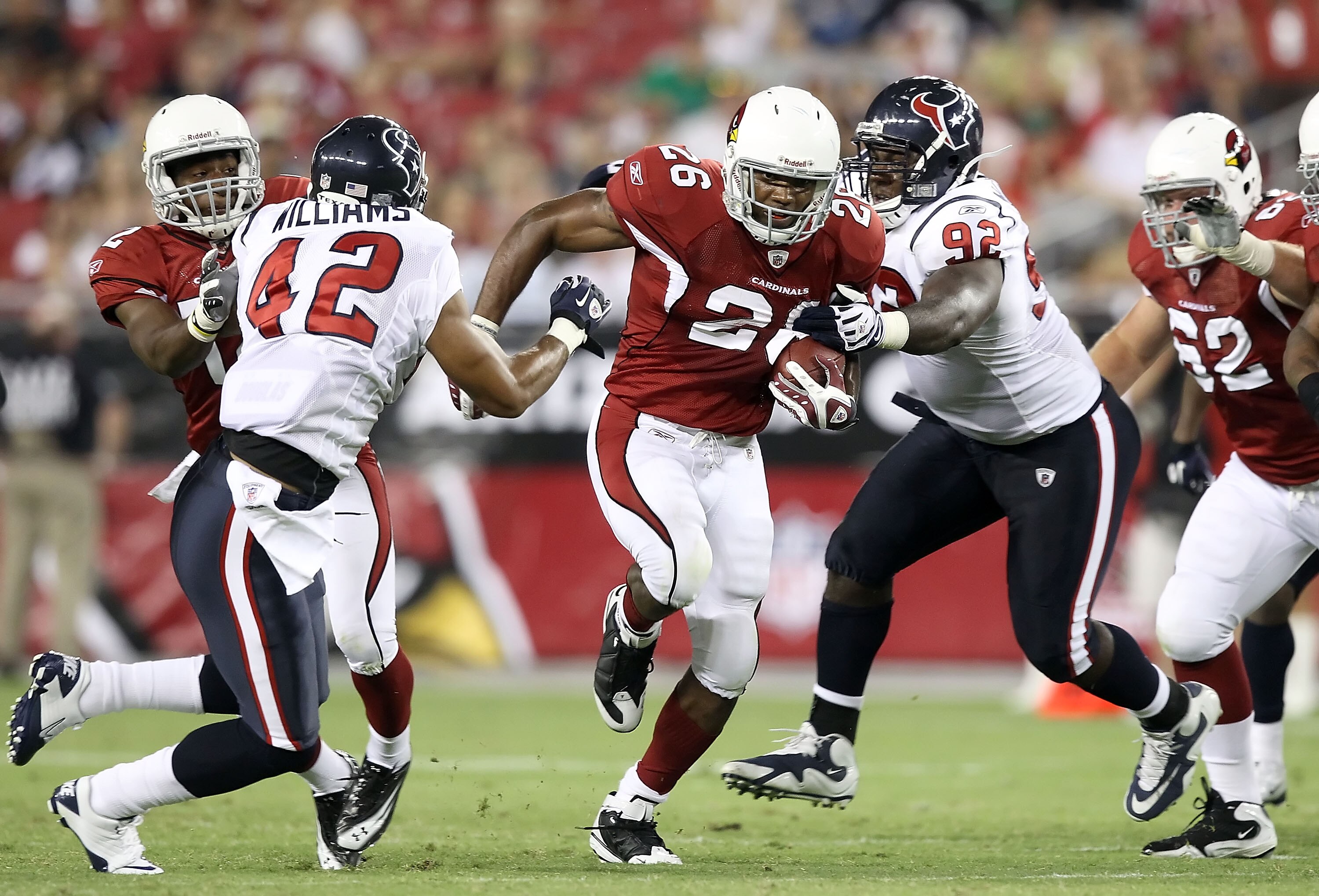 GLENDALE, AZ - AUGUST 14:  Runningback Beanie Wells #26 of the Arizona Cardinals carries the ball for a 10 yard rush past Earl Mitchell #91 of the Houston Texans during preseason NFL game at the University of Phoenix Stadium on August 14, 2010 in Glendale