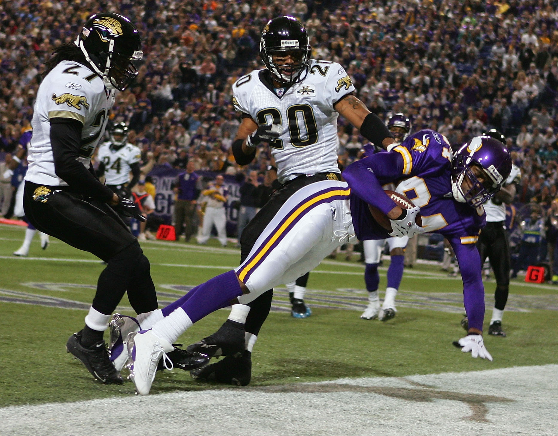 MINNEAPOLIS - NOVEMBER 28:  Randy Moss #84 of the Minnesota Vikings scores as Donovin Darius #20 and Rashean Mathis #27 of the Jacksonville Jaguars defend on November 28, 2004 at the Hubert H. Humphrey Metrodome in Minneapolis, Minnesota. The Minnesota Vi