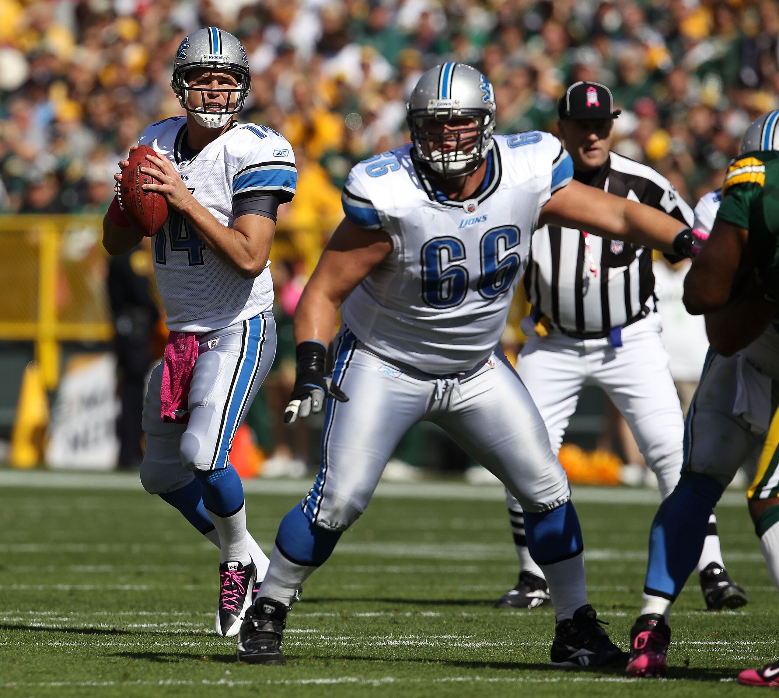 GREEN BAY, WI - OCTOBER 03: Shaun Hill #14 of the Detroit Lions drops back to pass as teammate Stephen Petermen #66 looks to block against the Green Bay Packers at Lambeau Field on October 3, 2010 in Green Bay, Wisconsin. The Packers defeated the Lions 28