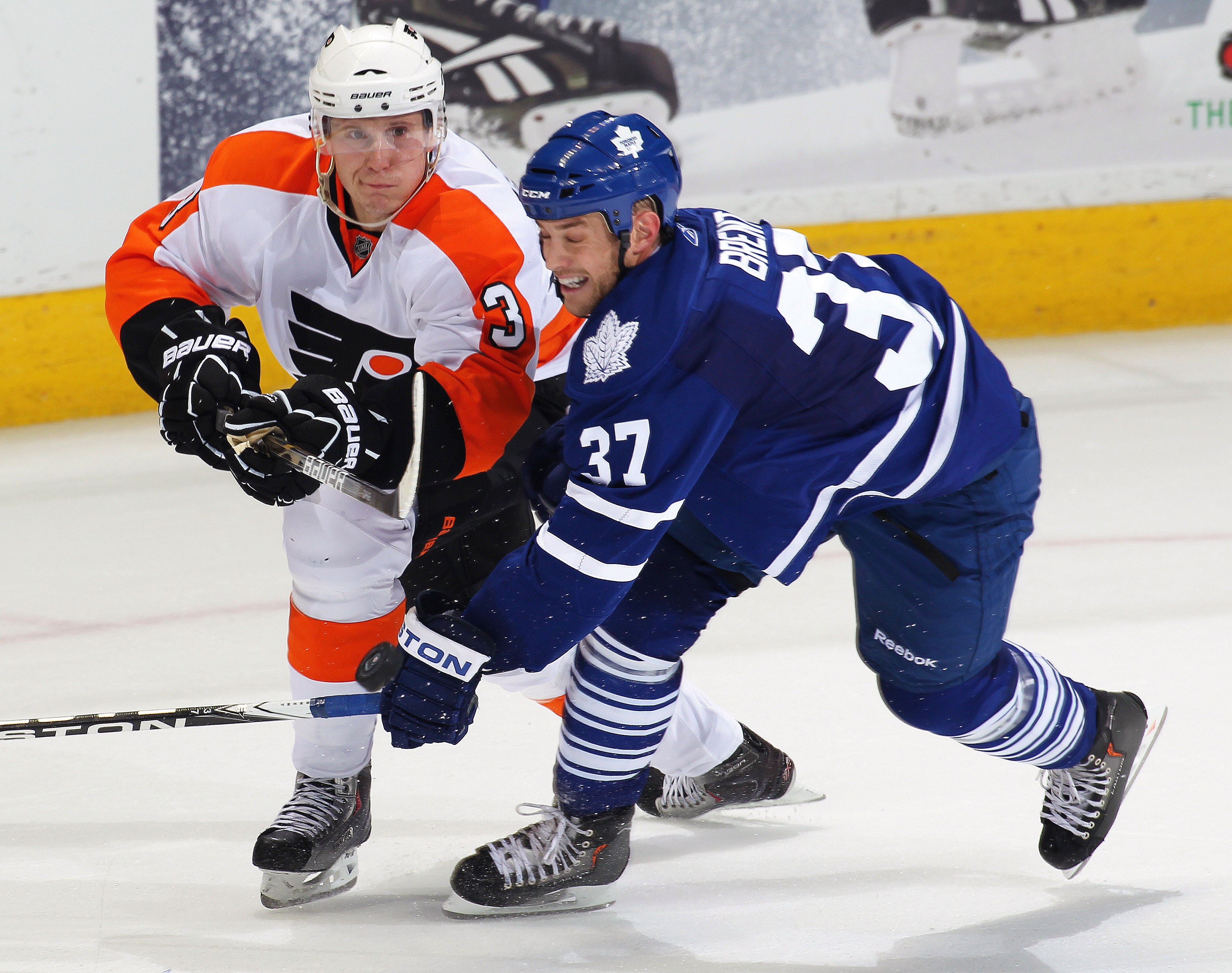 LONDON,ON - SEPTEMBER 23:  Oskars Bartulis #3 of the Philadelphia Flyers flips the puck past Tim Brent #37 of the Toronto Maple Leafs skates in a pre-season game on September 23, 2010 at the John Labatt Centre in London, Ontario, Canada.  (Photo by Claus 