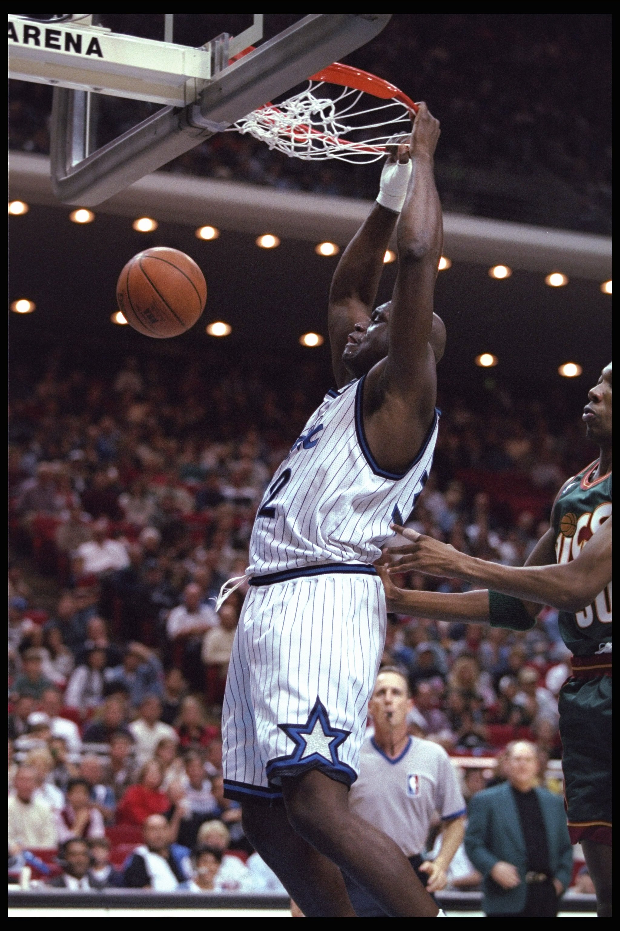 5 Jan 1996:  Center Shaquille O'Neal of the Orlando Magic sinks the ball as Ervin Johnson of the Seattle Supersonics looks on during a game played at the Orlando Arena in Orlando, Florida.  The Magic won the game, 115-93. Mandatory Credit: ALLSPORT USA/Al