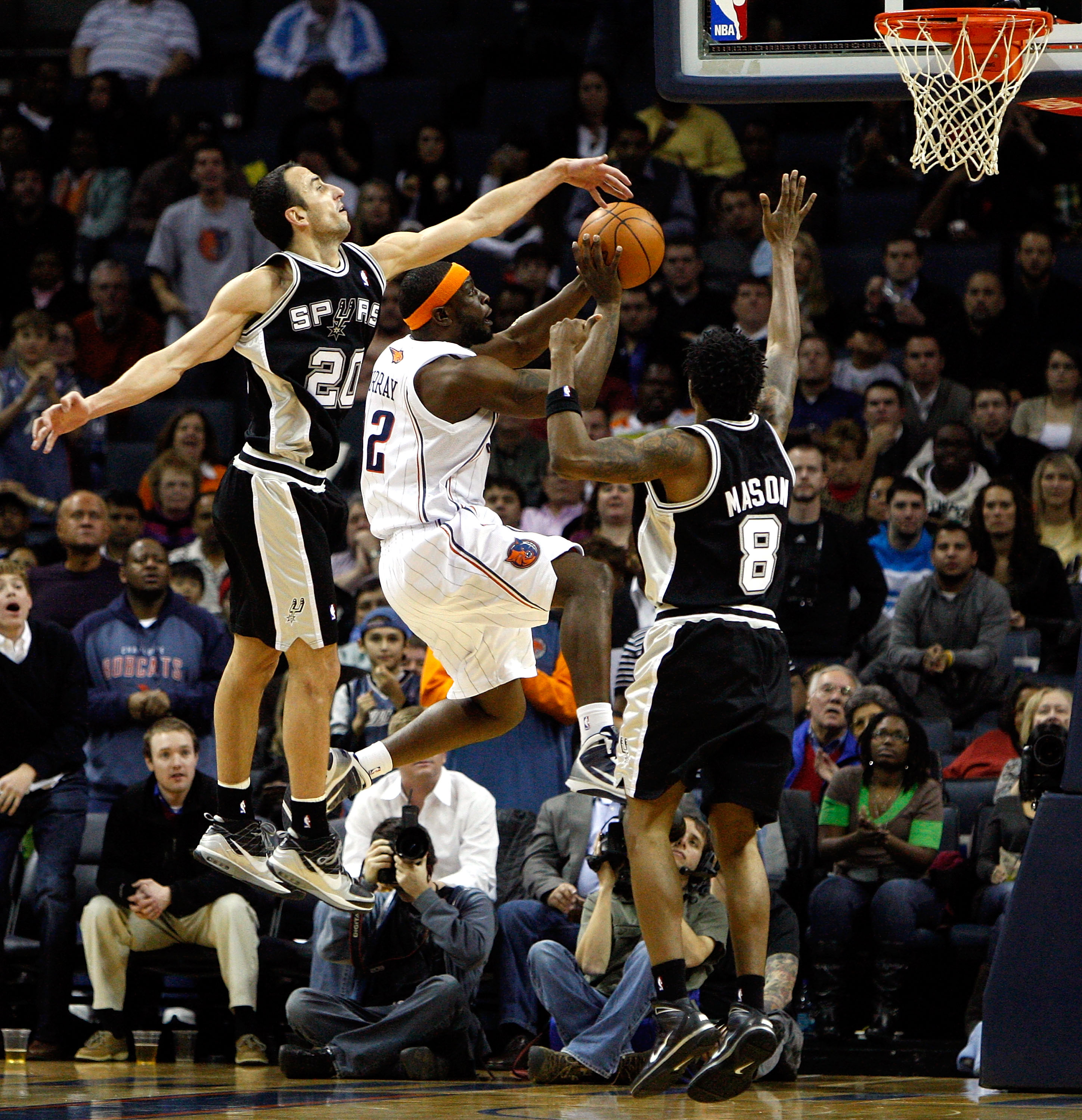 CHARLOTTE, NC - JANUARY 15:  Teammates Manu Ginobili #20 and Roger Mason Jr. #8 of the San Antonio Spurs try to stop Ronald 'Flipp' Murray #22 of the Charlotte Bobcats during their game at Time Warner Cable Arena on January 15, 2010 in Charlotte, North Ca