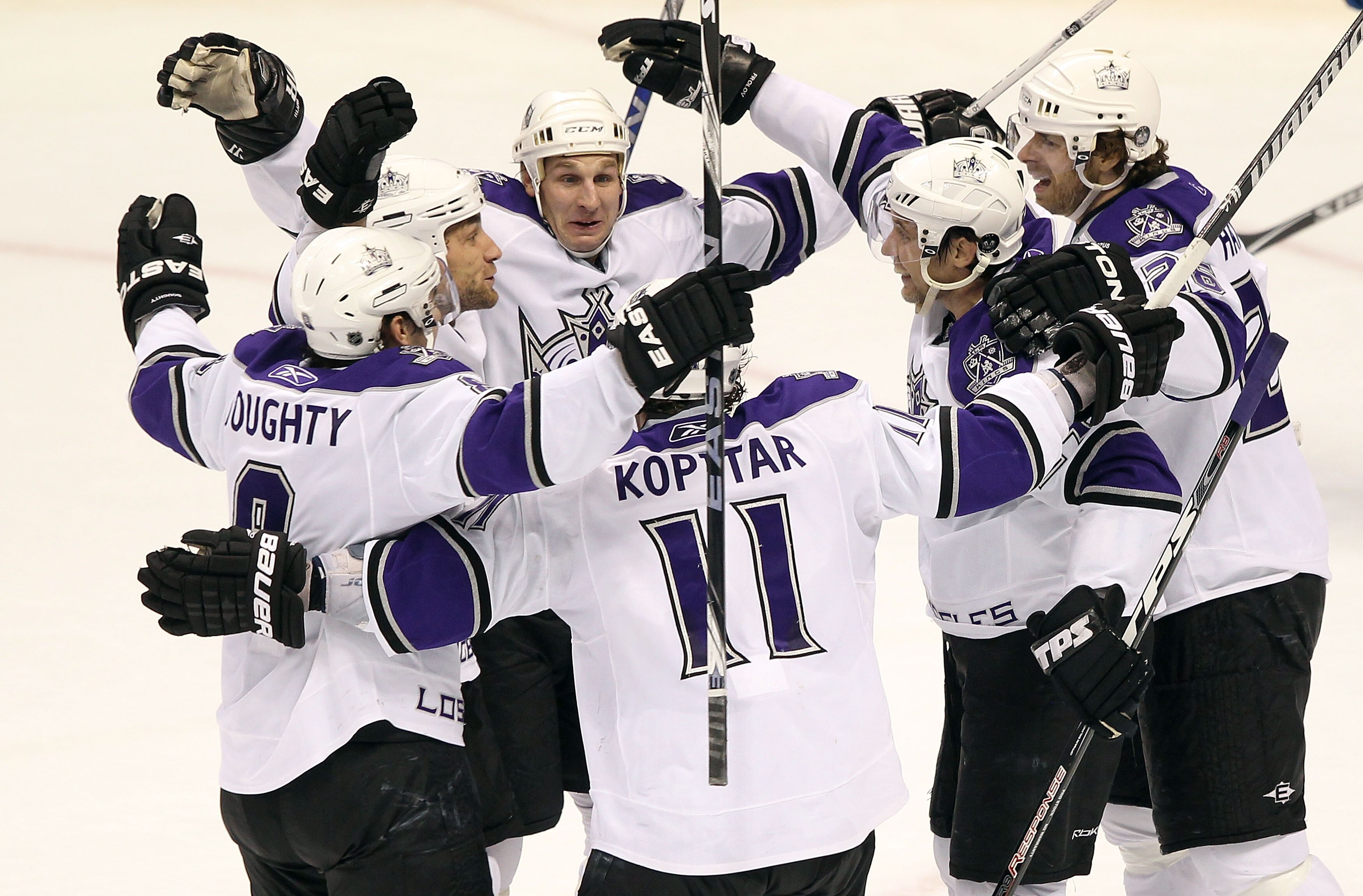 DENVER - MARCH 24:  Alexander Frolov (second from right) #24 of the Los Angeles Kings is congratulated by teammates (L-R) Drew Doughty #8, Jarrett Stoll #28, Ryan Smyth #94, Anze Kopitar #11 and Michal Handzus #26 after his game tying goal in the third pe