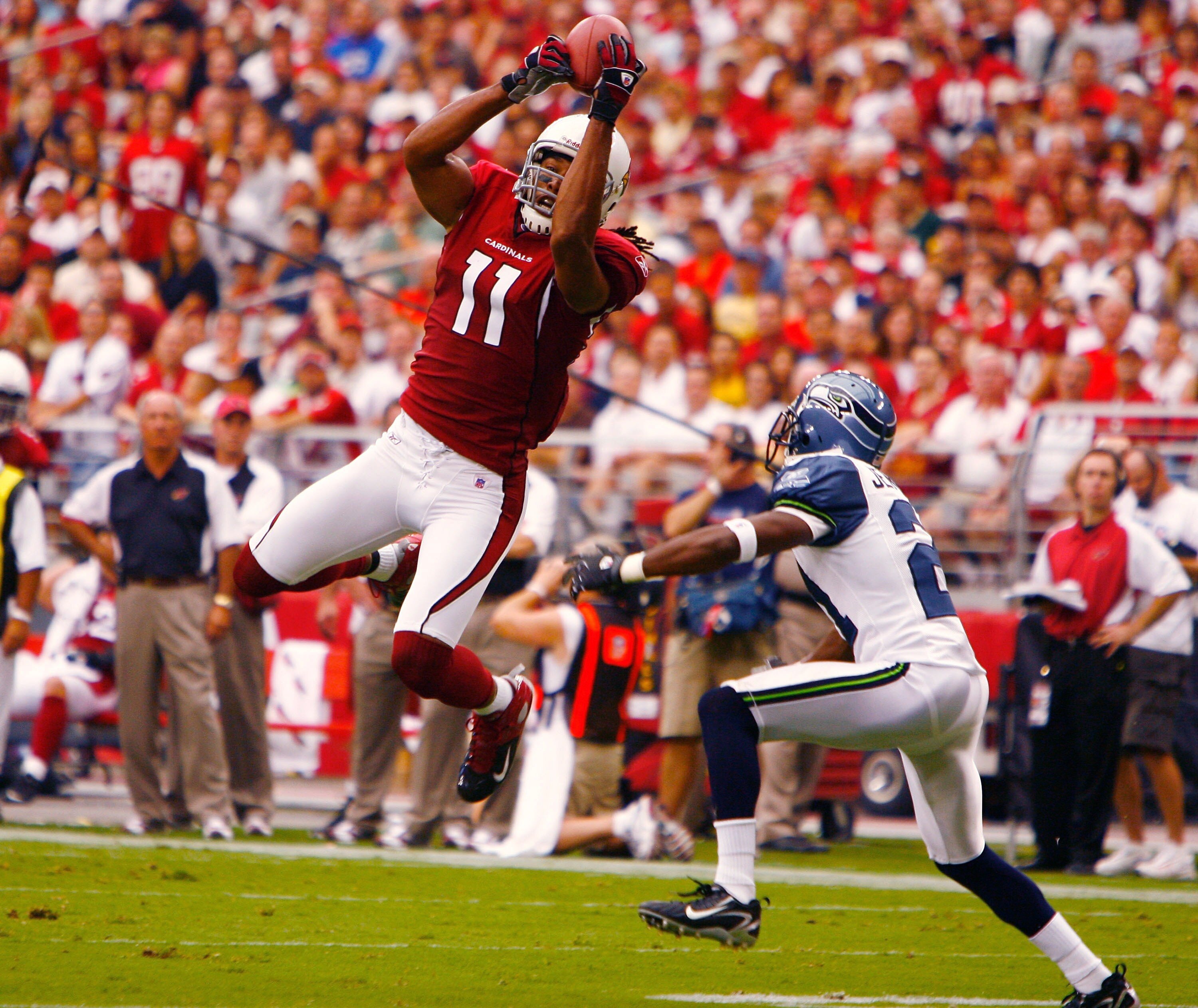 GLENDALE, AZ - SEPTEMBER 16:   Larry Fitzgerald #11 of the Arizona Cardinals leaps high to grab a pass against the Seattle Seahawks at University of Phoenix Stadium on September 16, 2007 in Glendale, Arizona.  The Cardinals defeated the Seahawks 23-20.  (