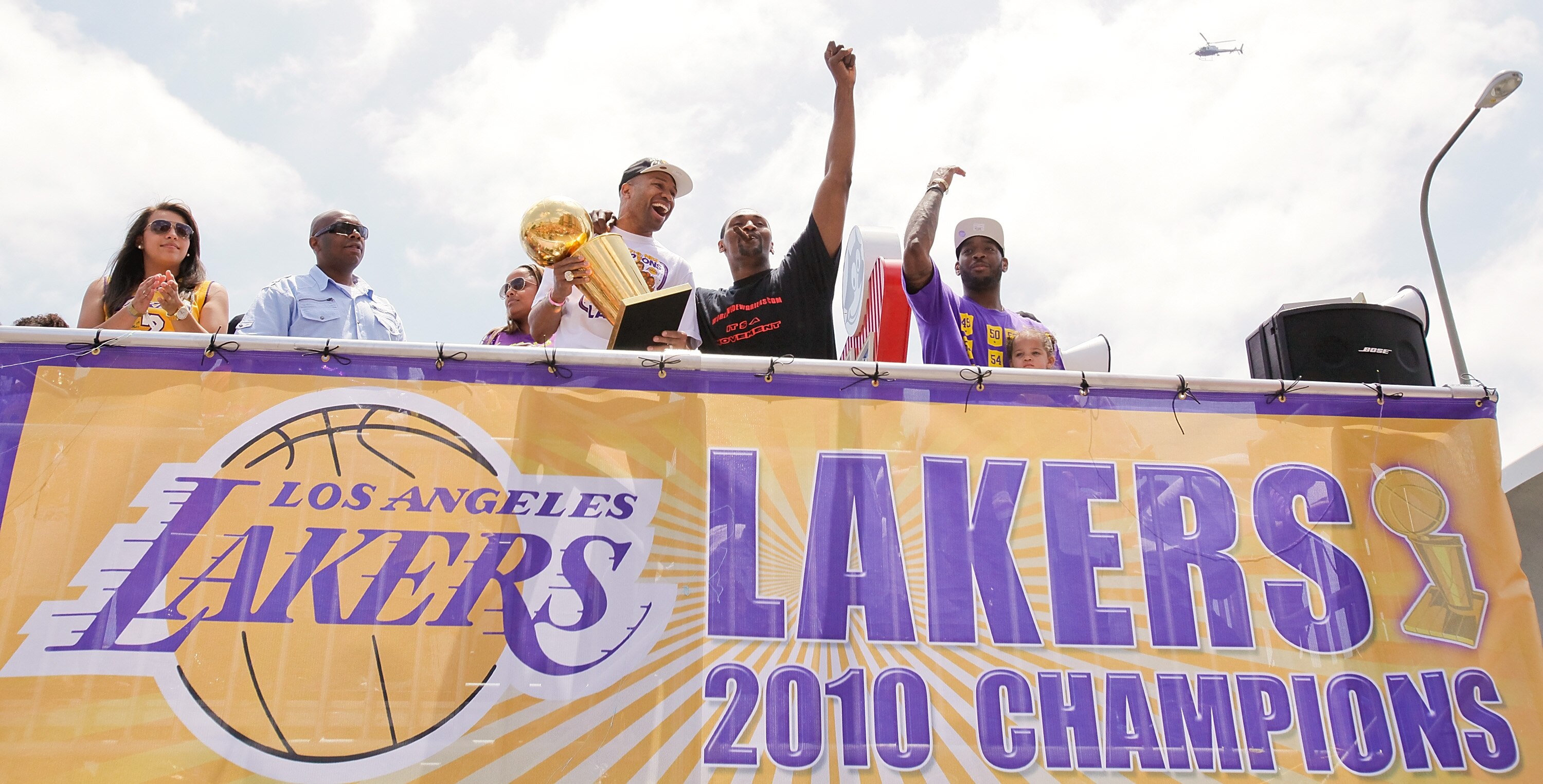 LOS ANGELES, CA - JUNE 21:  (3L-R) Los Angeles Lakers point guard Derek Fisher hoists the championship trophy with small forward Ron Artest (C) and power forward Josh Powell (R) while riding in the victory parade for the the NBA basketball champion team o