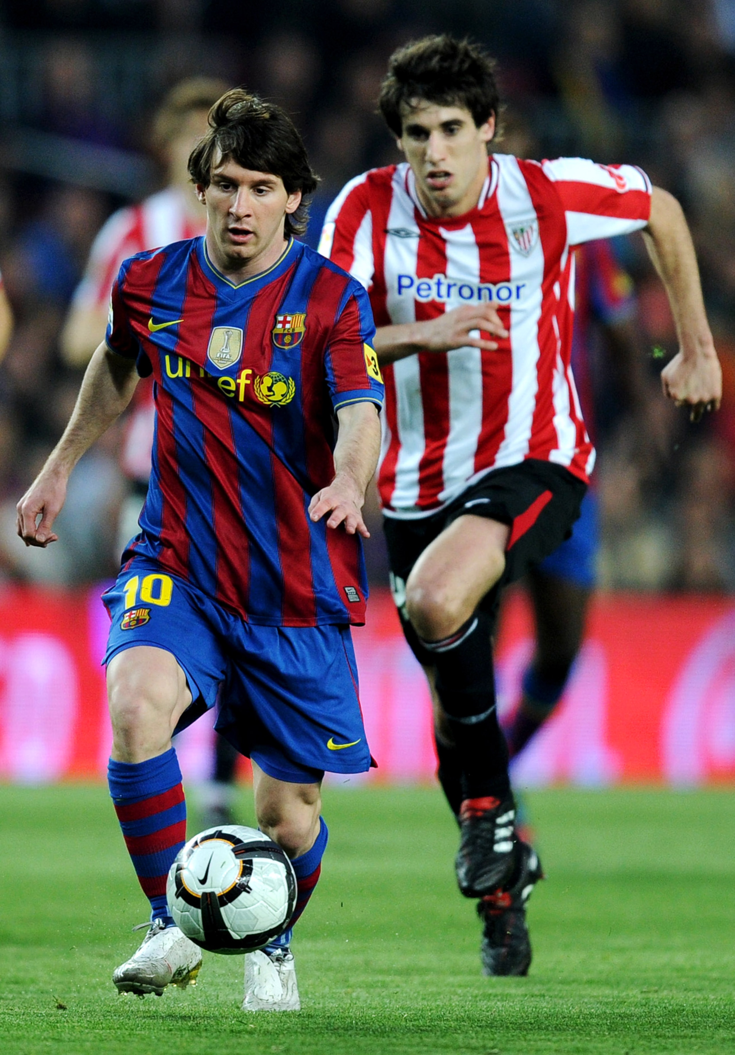 BARCELONA, SPAIN - APRIL 03:  Lionel Messi (L) of FC Barcelona runs for the ball pursued by Javi Martinez of Athletic Bilbao during the La Liga match between Barcelona and Athletic Bilbao at the Camp Nou Stadium on April 3, 2010 in Barcelona, Spain. Barce