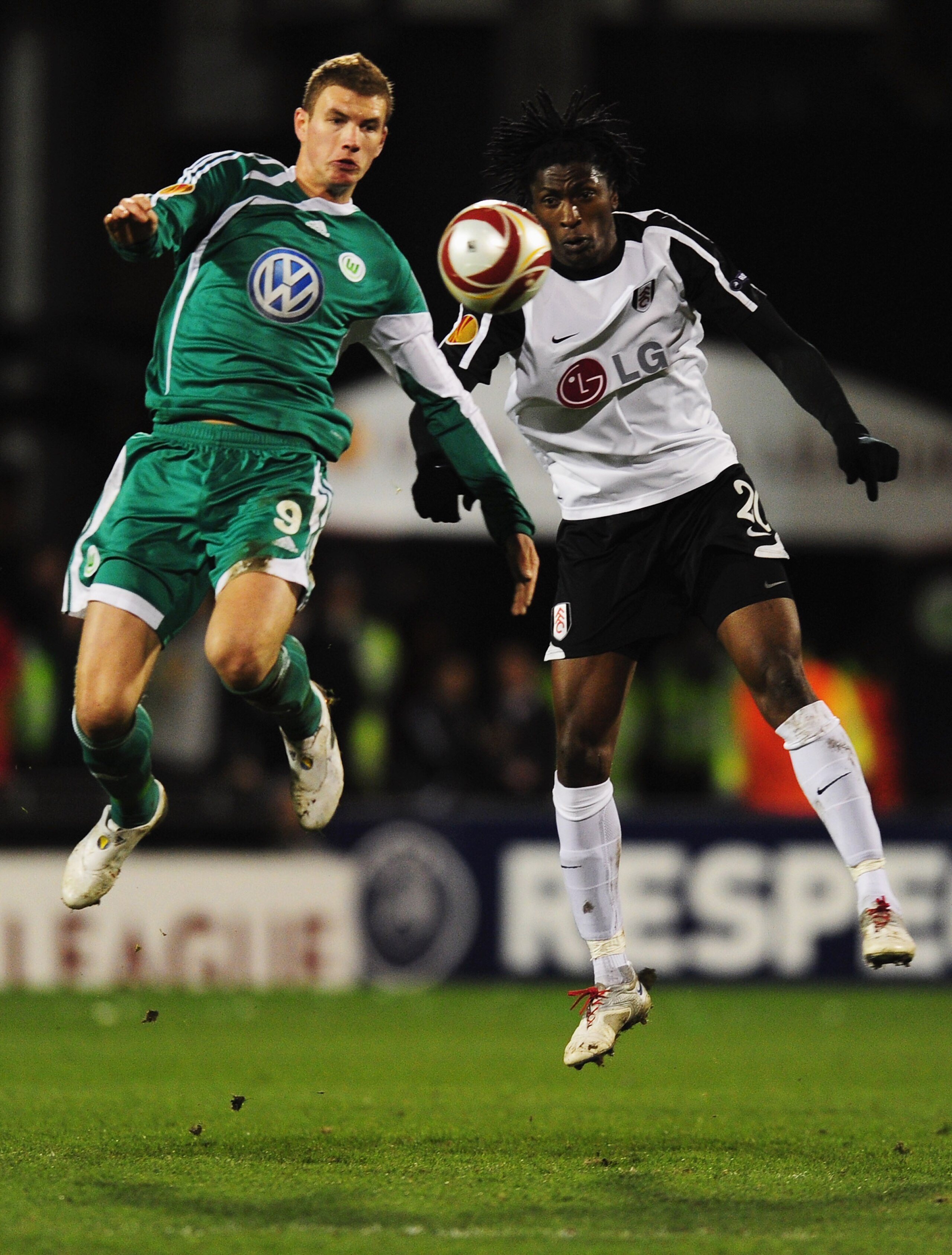 LONDON, ENGLAND - APRIL 01:  Dickson Etuhu of Fulham jumps with Edin Dzeko of VfL Wolfsburg (R) during the UEFA Europa League quarter final first leg match between Fulham and Vfl Wolfsburg at Craven Cottage on April 1, 2010 in London, England.  (Photo by 