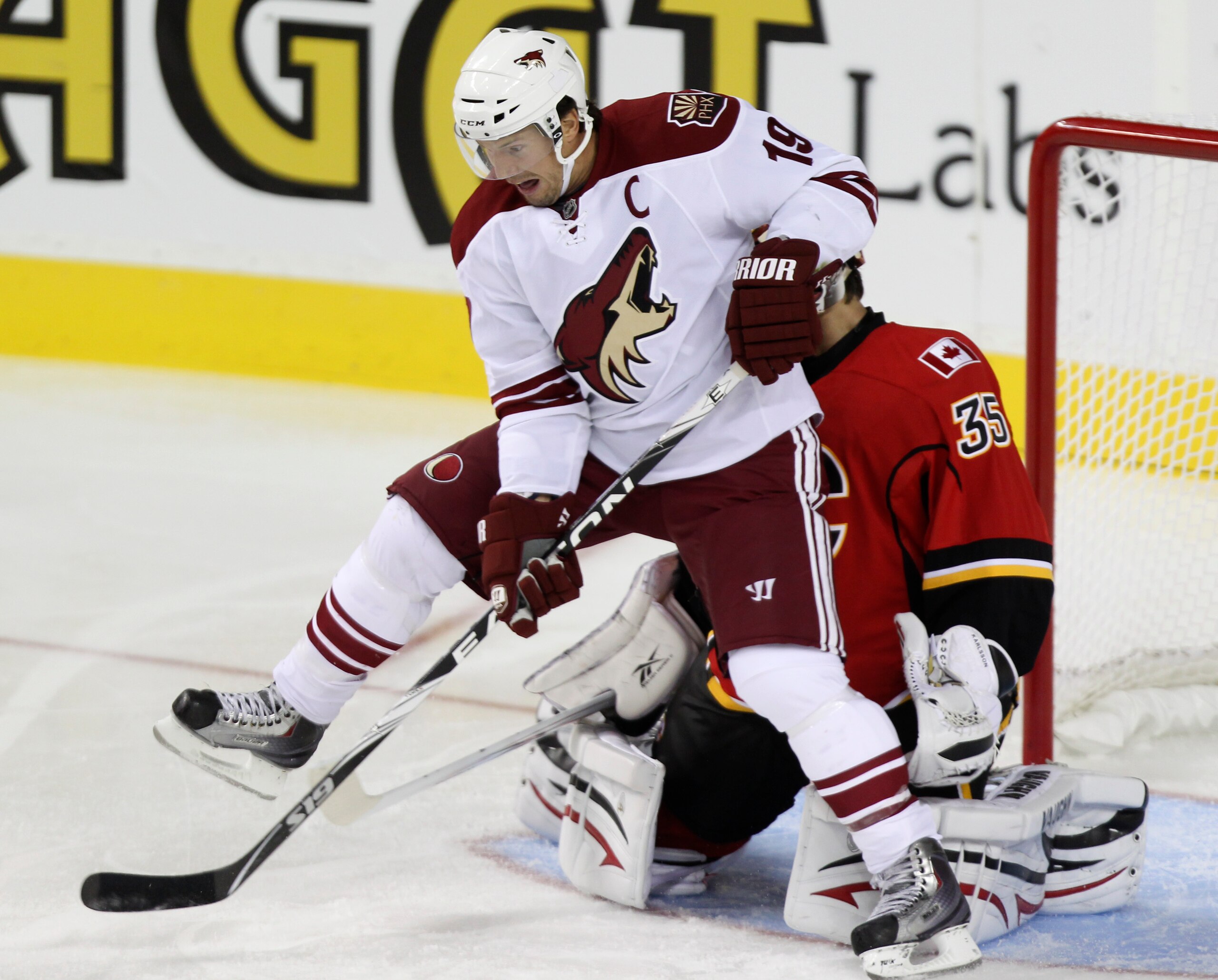 CALGARY, AB - SEPTEMBER 28: Goaltender Henrik Karlsson #35 of the Calgary Flames is blocked by Shane Doan #19 the Phoenix Coyotes in NHL preseason action on September 28, 2010 at the Pengrowth Saddledome in Calgary, Alberta, Canada. (Photo by Mike Ridewoo