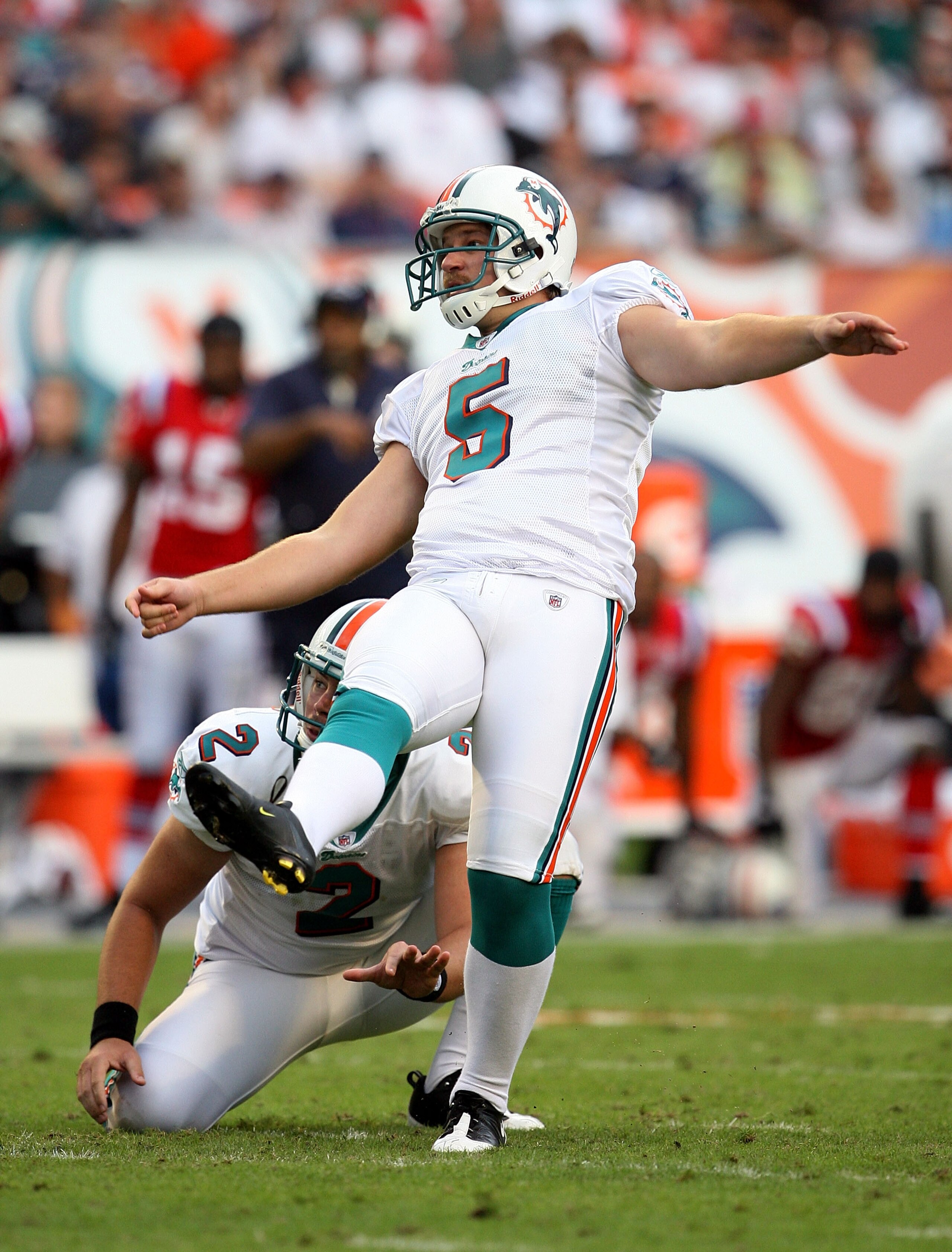 MIAMI - DECEMBER 06:  Place kicker Dan Carpenter #5 of the Miami Dolphins follows through on a game-winning field goal from under the hold of punter Brandon Fields #2 late in the game against the New England Patriots at Land Shark Stadium on December 6, 2