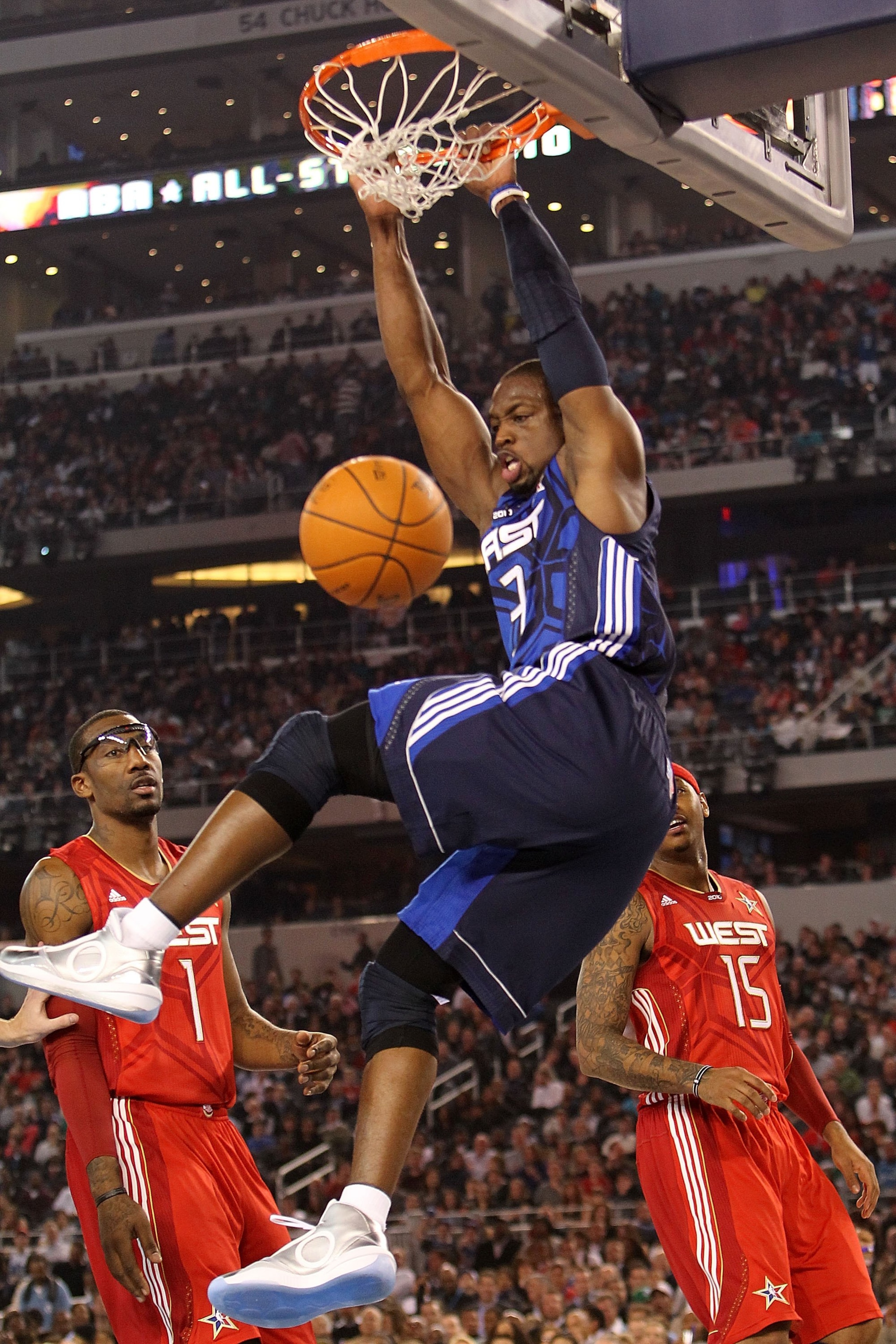 ARLINGTON, TX - FEBRUARY 14:  Dwyane Wade #3 of the Eastern Conference hangs on the rim after dunking against Amar'e Stoudemire #1 and Carmelo Anthony #15 of the Western Conference during the second half of the NBA All-Star Game, part of 2010 NBA All-Star