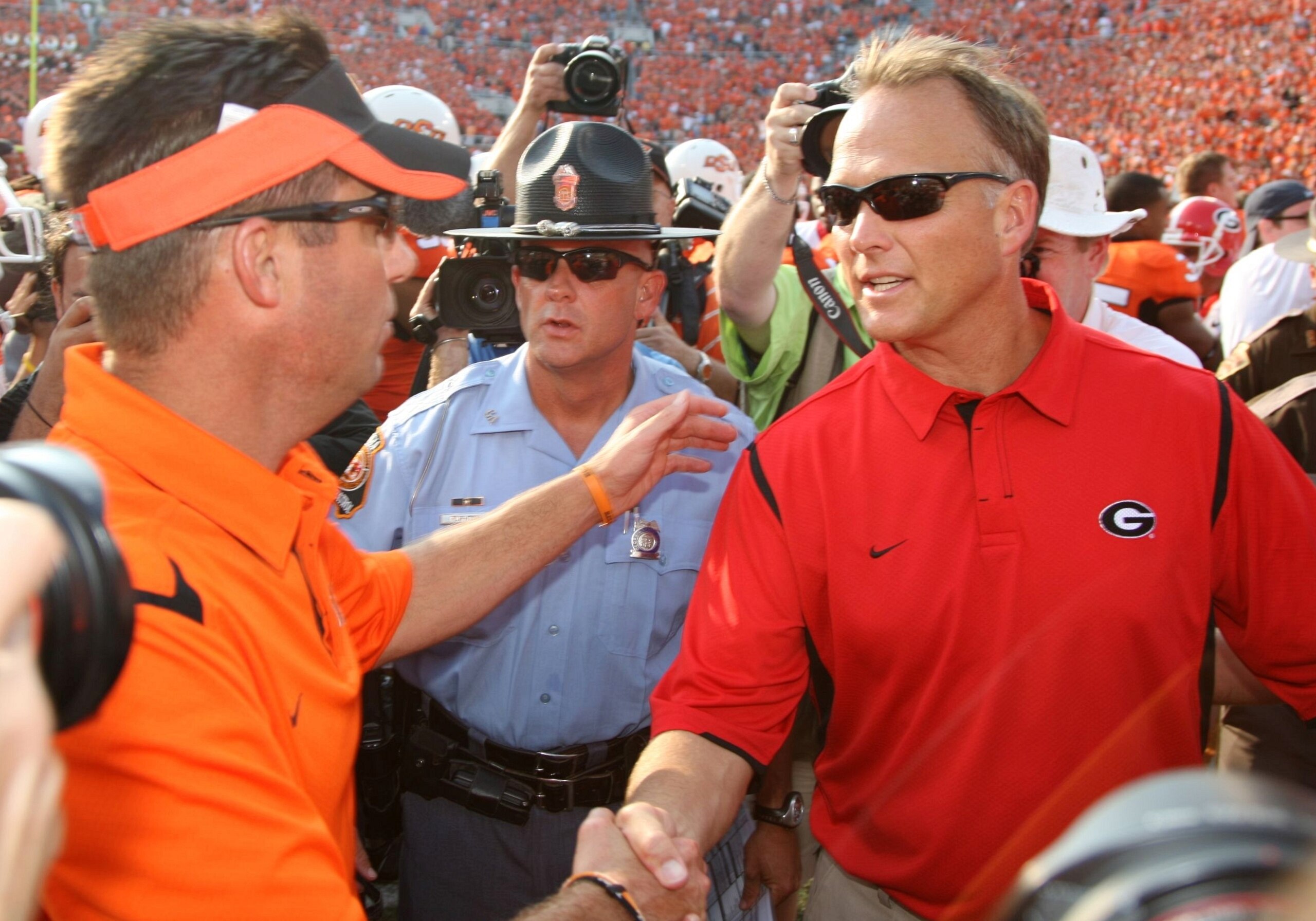 STILLWATER, OK - SEPTEMBER 5:  Head coach Mark Richt of the Georgia Bulldogs congratulates head coach Mike Gundy of the Oklahoma State Cowboys after the Cowboys won the game 24-10 at Boone Pickens Stadium on September 5, 2009 in Stillwater, Oklahoma. (Pho