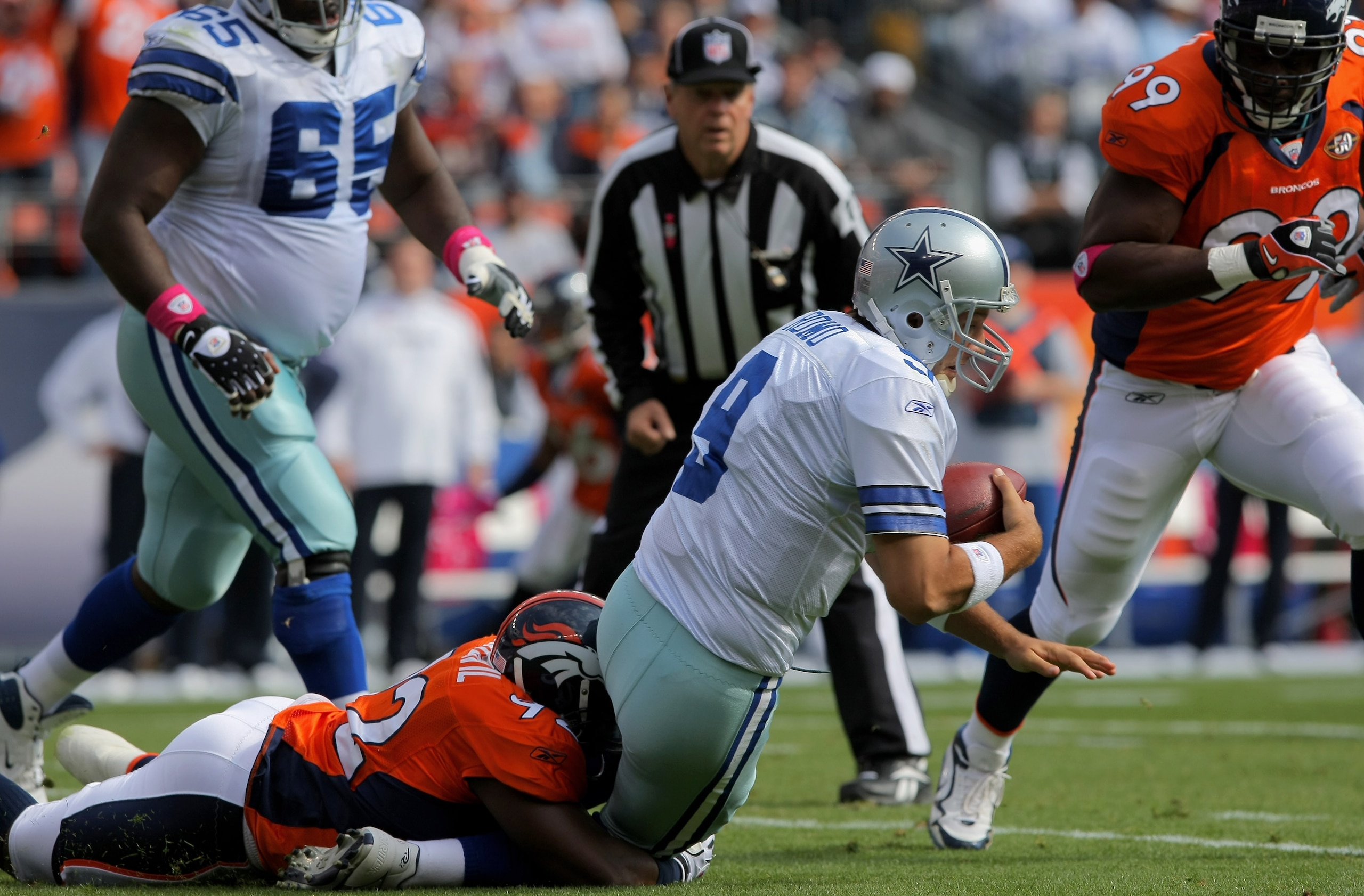 DENVER - OCTOBER 04:  Elivs Dumervil #92 of the Denver Broncos sacks quarterback Tony Romo #9 of the Dallas Cowboys during NFL action at Invesco Field at Mile High on October 4, 2009 in Denver, Colorado. The Broncos defeated the Cowboys 17-10.  (Photo by