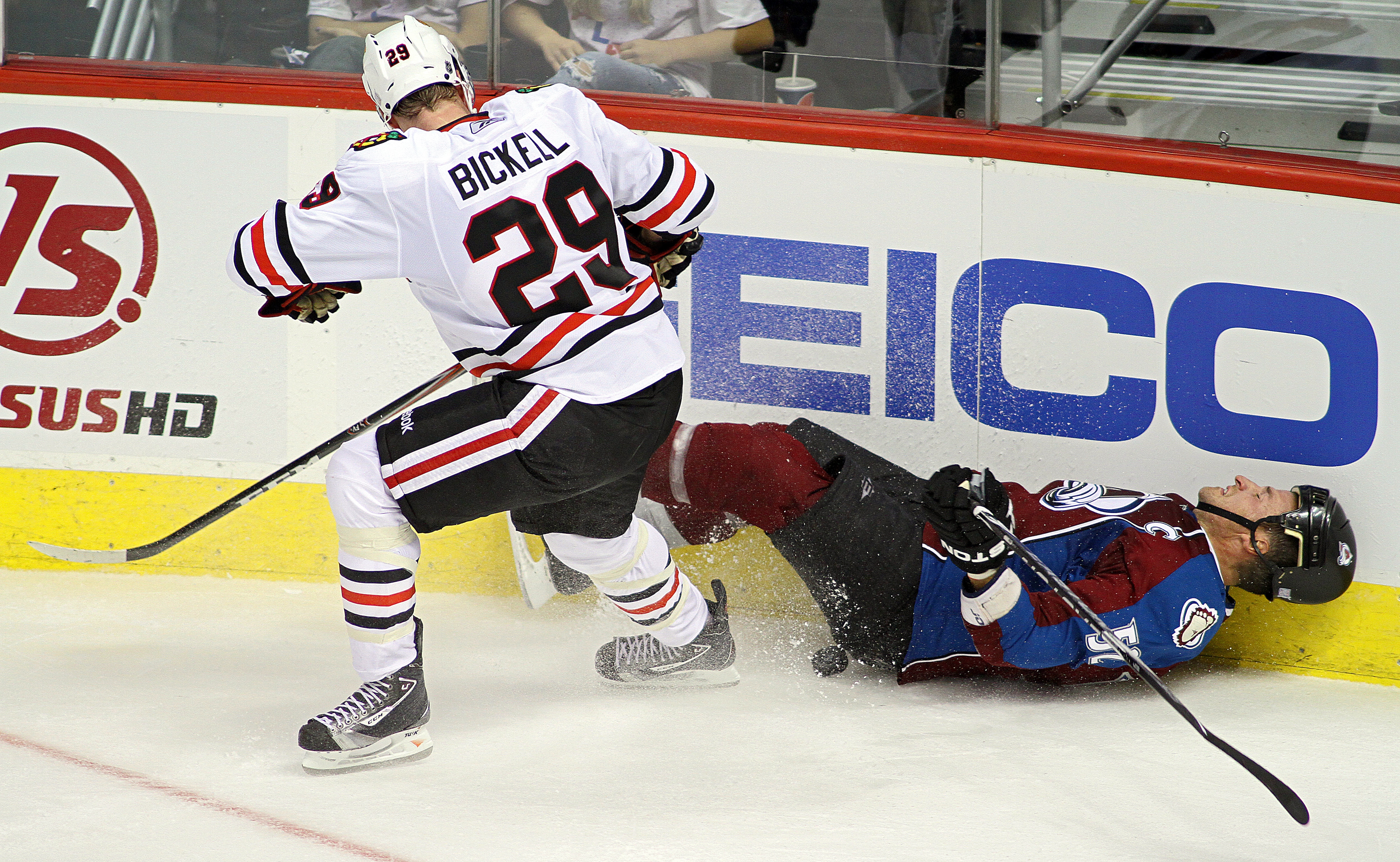 DENVER, CO - OCTOBER 7: Adam Foote #52 of the Colorado Avalanche gets taken down in the corner by Bryan Bickell #29 of the Chicago Blackhawks during both team's season openers at the Pepsi Center on October 7, 2010 in Denver, Colorado. The Avalanche won t