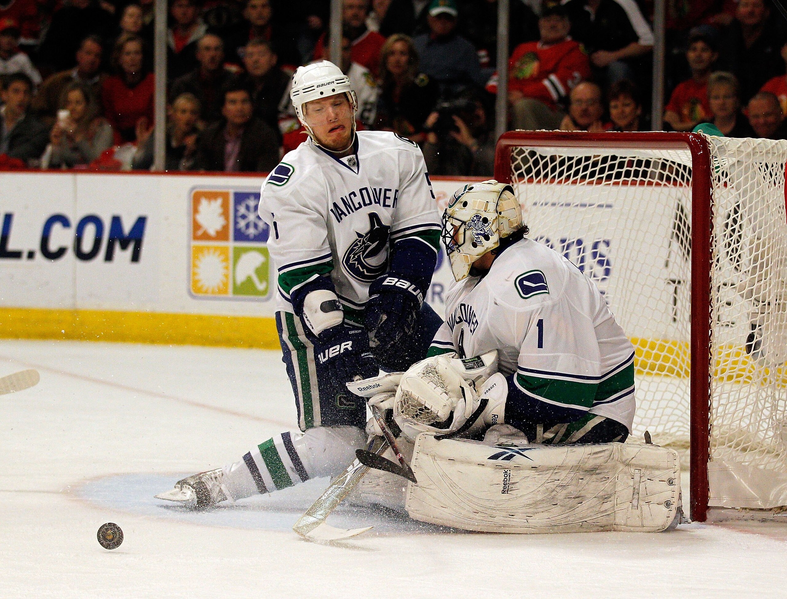 CHICAGO - MAY 09: Christian Ehrhoff #5 and Roberto Luongo #1 of the Vancouver Canucks reject the puck against the Chicago Blackhawks in Game Five of the Western Conference Semifinals during the 2010 NHL Stanley Cup Playoffs at United Center on May 9, 2010