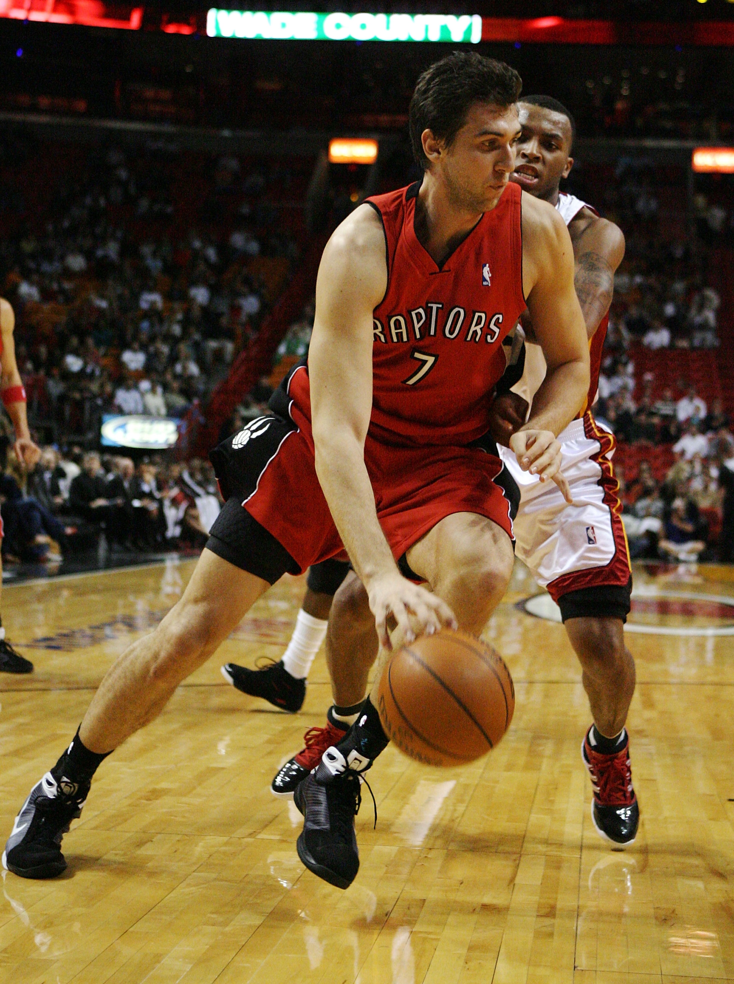 MIAMI - NOVEMBER 19:  Andrea Bargnani #7 of the Toronto Raptors drives past Daequan Cook #14 of the Miami Heat at American Airlines Arena on November 19, 2008 in Miami, Florida. The Raptors defeated the Heat 101-95. NOTE TO USER: User expressly acknowledg