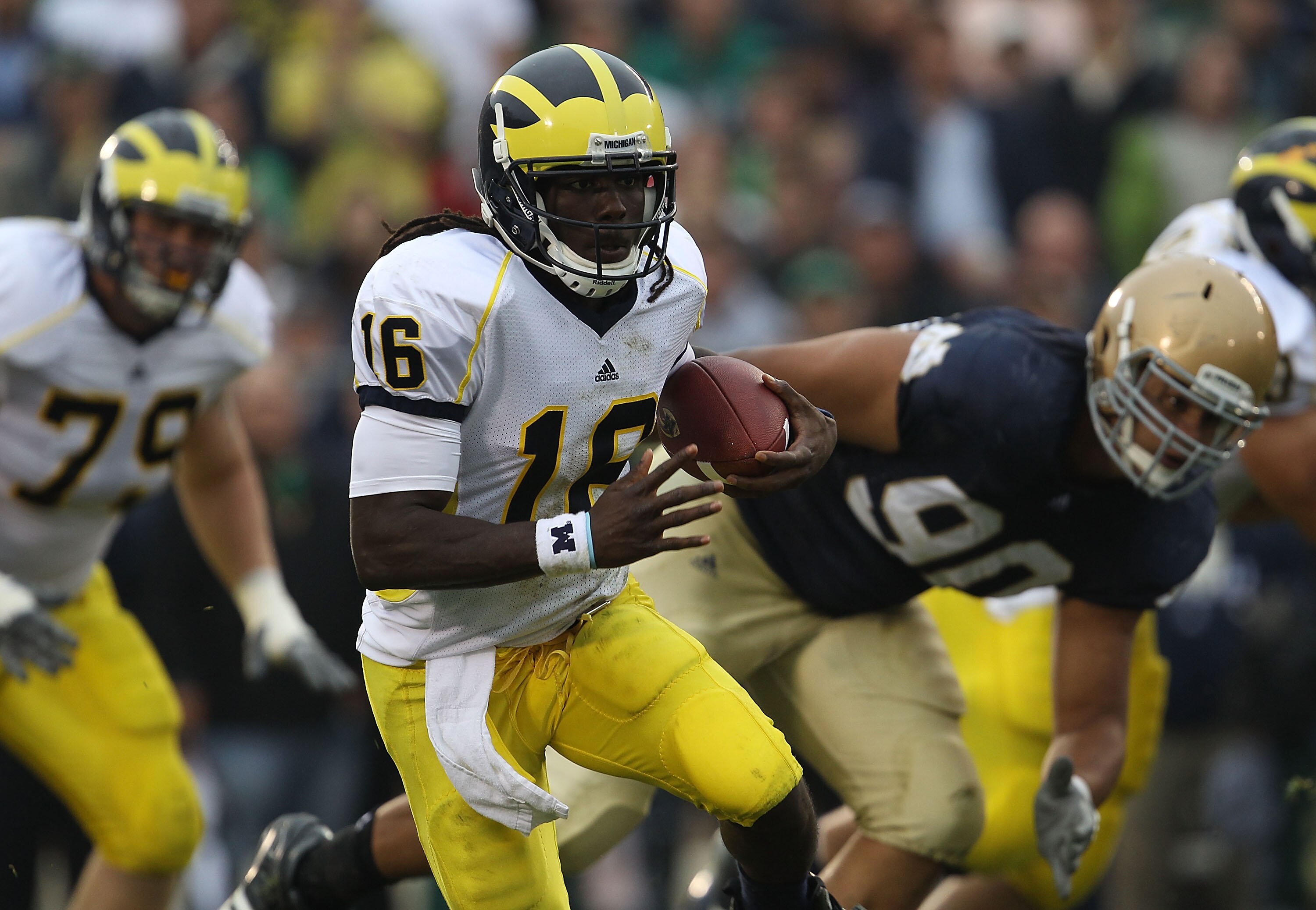SOUTH BEND, IN - SEPTEMBER 11: Denard Robinson #16 of the Michigan Wolverines runs past Ethan Johnson #90 of the Notre Dame Fighting Irish at Notre Dame Stadium on September 11, 2010 in South Bend, Indiana. Michigan defeated Notre Dame 28-24.  (Photo by J