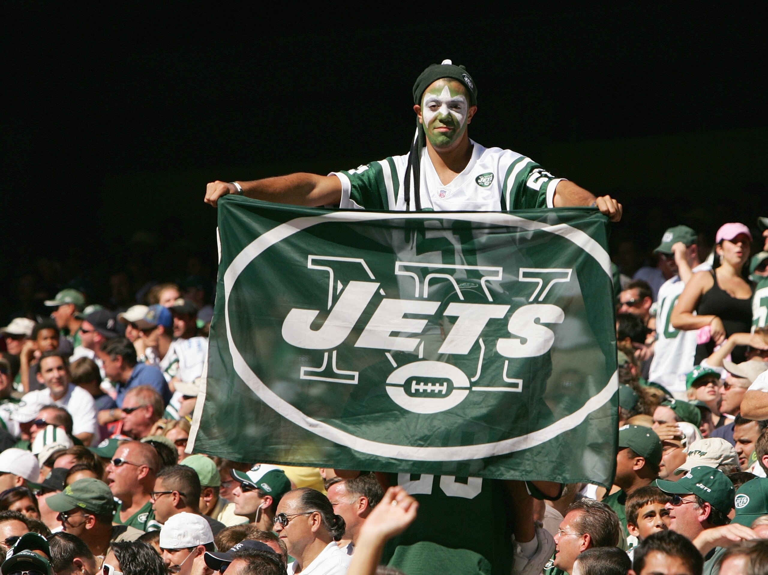 EAST RUTHERFORD, NJ - SEPTEMBER 23: A fan of the New York Jets holds up a Jets flag during the game against the Miami Dolphins on September 23, 2007 at Giants Stadium in East Rutherford, New Jersey. The Jets defeated the Dolphins 31-28. (Photo by Al Bello EAST RUTHERFORD, NJ - SEPTEMBER 23: A fan of the New York Jets holds up a Jets flag during the game against the Miami Dolphins on September 23, 2007 at Giants Stadium in East Rutherford, New Jersey. The Jets defeated the Dolphins 31-28. (Photo by Al Bello