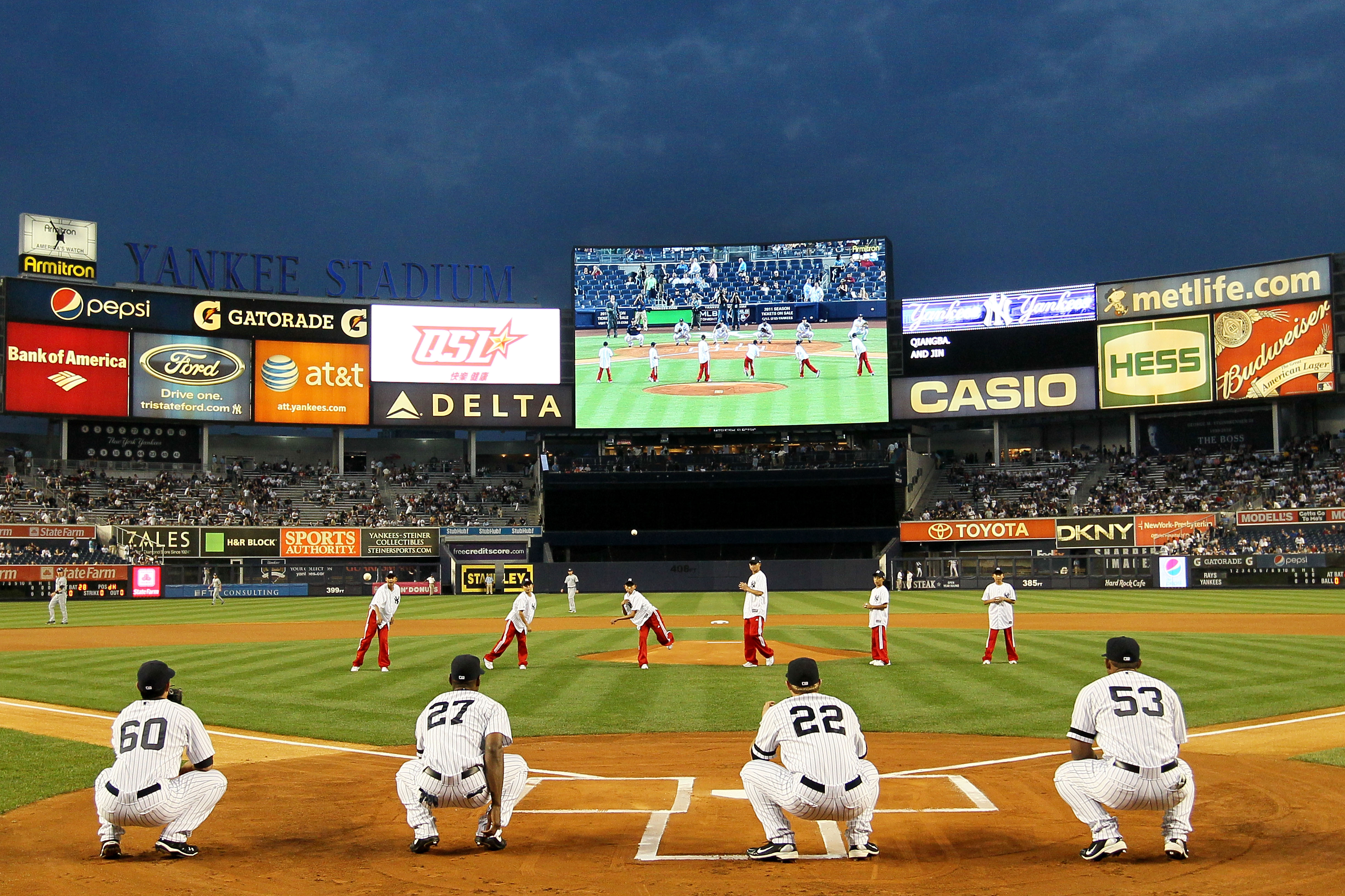 NEW YORK - SEPTEMBER 22: Members of the world championship winning China Youth Baseball League team throw out the first pitch prior to the start of the game between the New York Yankees and the Tampa Bay Rays during their game on September 22, 2010 at Yan
