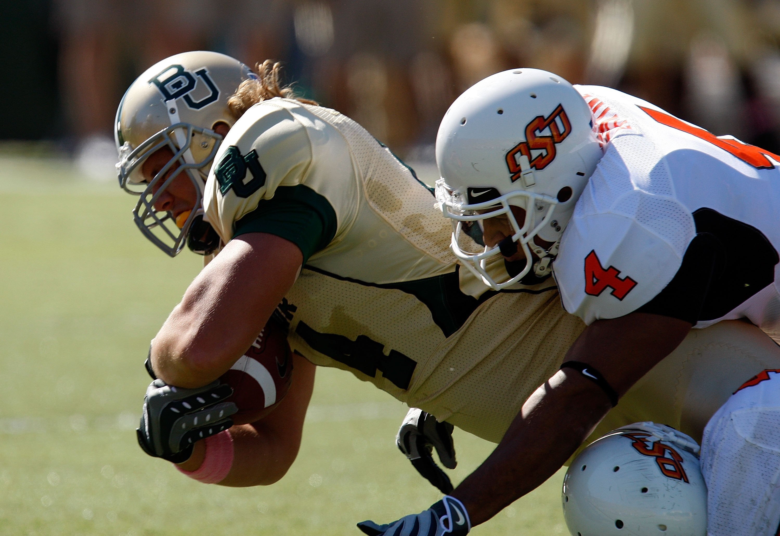 WACO, TX - OCTOBER 24:  Tight end Justin Akers #14 of the Baylor Bears is tackled by Patrick Lavine #4 of the Oklahoma State Cowboys at Floyd Casey Stadium on October 24, 2009 in Waco, Texas.  (Photo by Ronald Martinez/Getty Images)