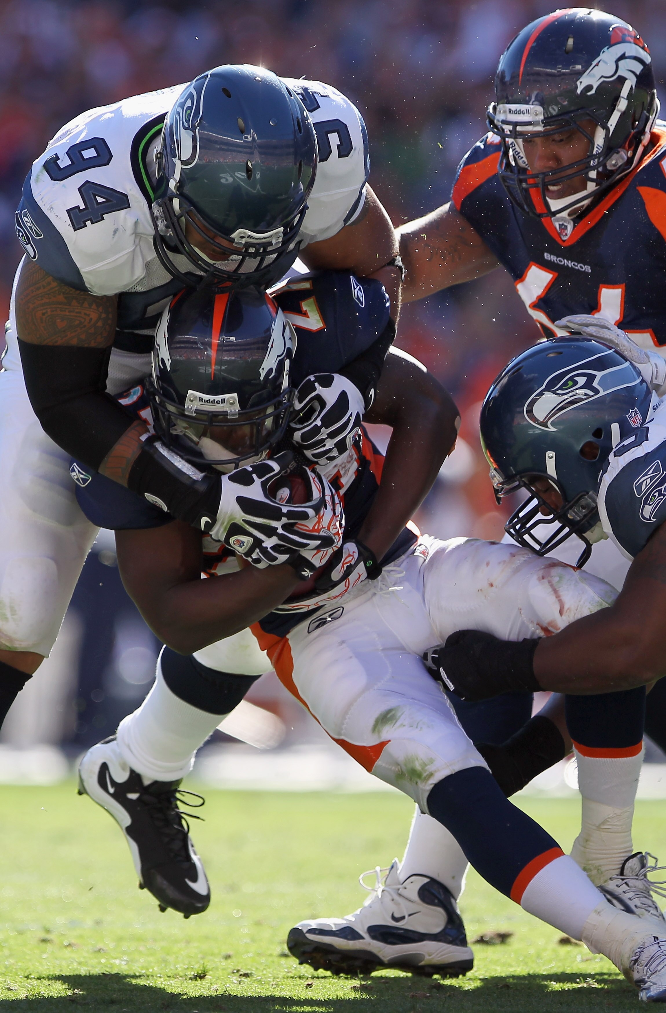 DENVER - SEPTEMBER 19:  Running back Knowshon Moreno #27 of the Denver Broncos is stopped for a loss by Junior Siavii #94 and Kentwan Balmer #95 of the Seattle Seahawks at INVESCO Field at Mile High on September 19, 2010 in Denver, Colorado. The Broncos d