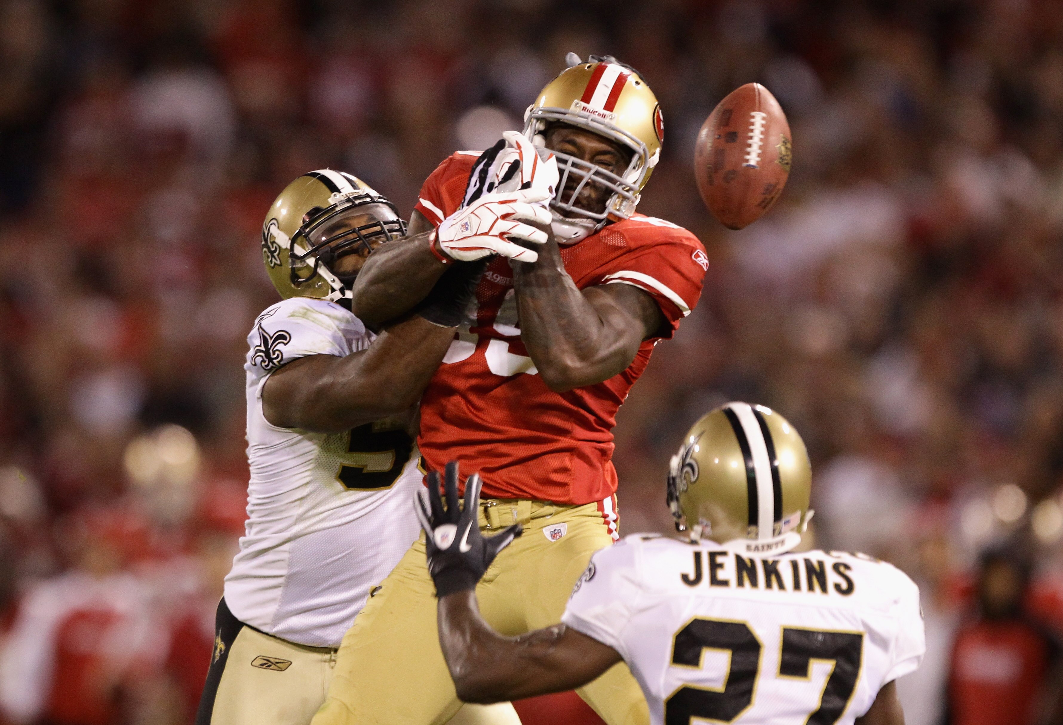 SAN FRANCISCO - SEPTEMBER 20:  Vernon Davis #85 of the San Francisco 49ers loses the ball while defended by Malcolm Jenkins #27 and Marvin Mitchell #50 of the New Orleans Saints at Candlestick Park on September 20, 2010 in San Francisco, California.  (Pho