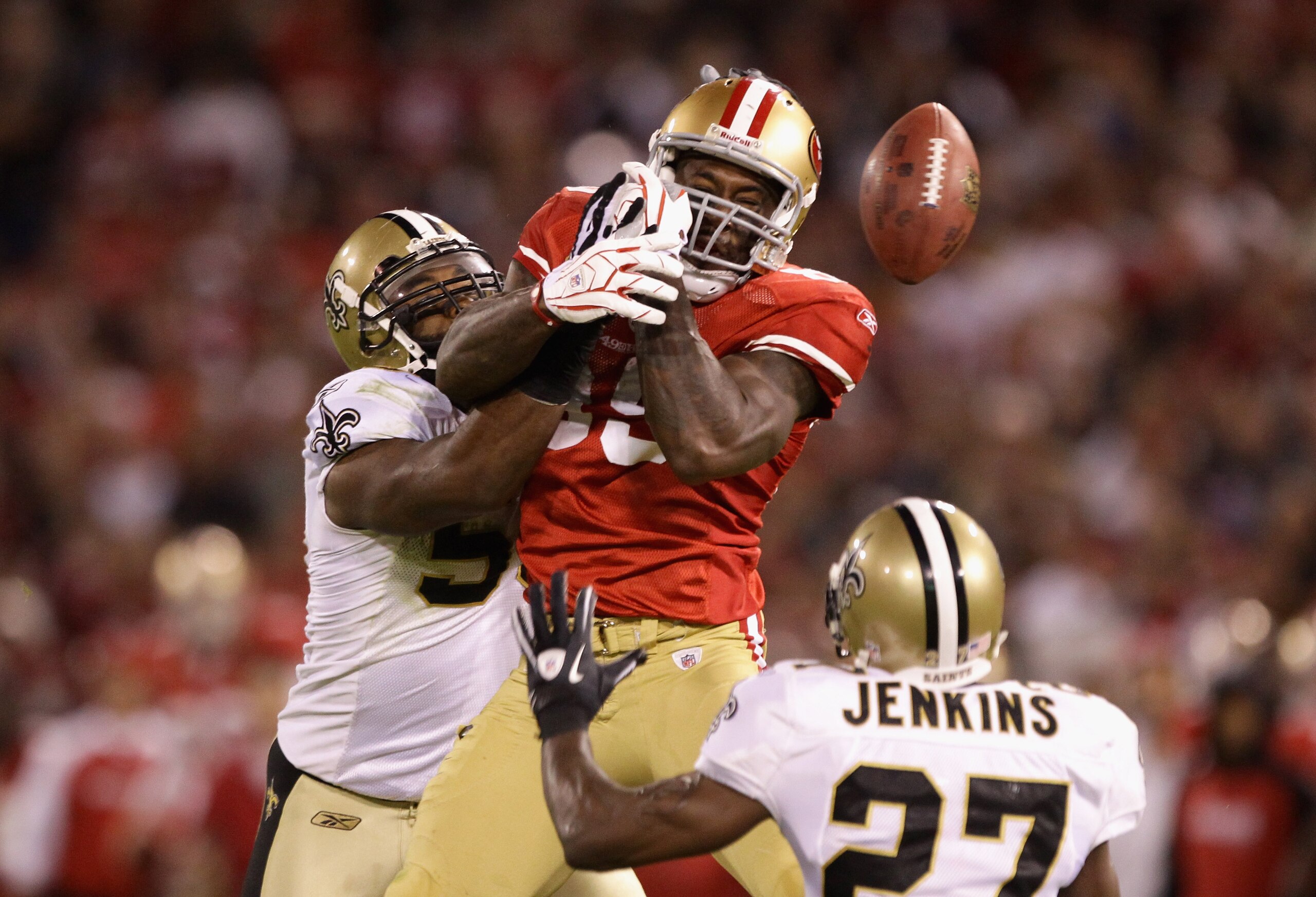 SAN FRANCISCO - SEPTEMBER 20:  Vernon Davis #85 of the San Francisco 49ers loses the ball while defended by Malcolm Jenkins #27 and Marvin Mitchell #50 of the New Orleans Saints at Candlestick Park on September 20, 2010 in San Francisco, California.  (Pho