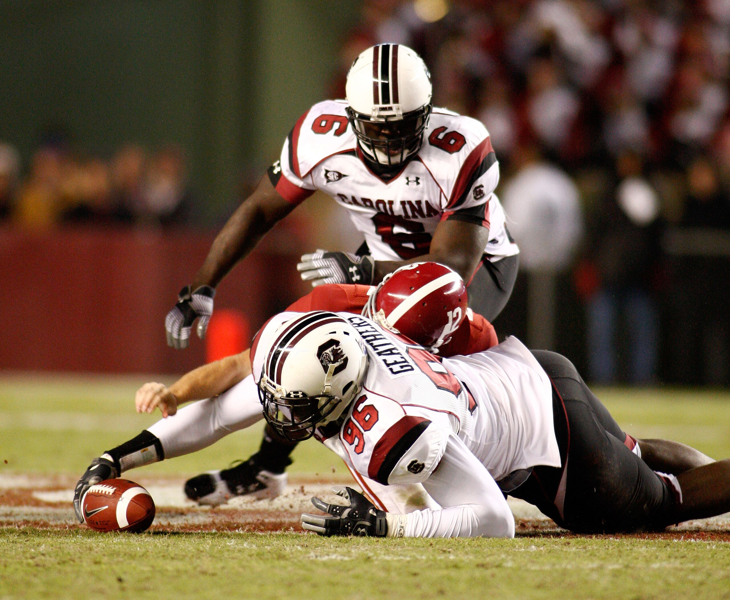 TUSCALOOSA - OCTOBER 17:  Defensive end Clifton Geathers #96 of the South Carolina Gamecocks recovers a fumble by quarterback Greg McElroy #12 of the Alabama Crimson Tide while Geathers' teammate Melvin Ingram #6 looks on during the game at Bryant-Denny S