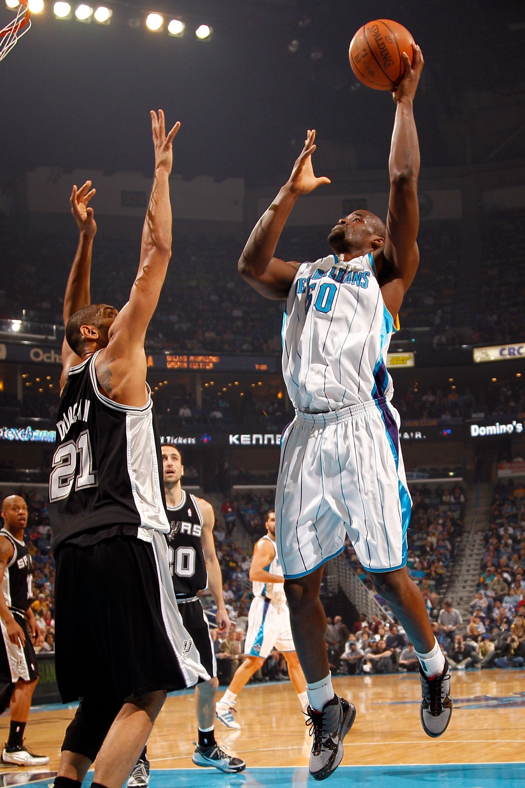 NEW ORLEANS - JANUARY 18:  Emeka Okafor #50 of the New Orleans Hornets shoots the ball over Tim Duncan #21 of the San Antonio Spurs at New Orleans Arena on January 18, 2010 in New Orleans, Louisiana.   NOTE TO USER: User expressly acknowledges and agrees