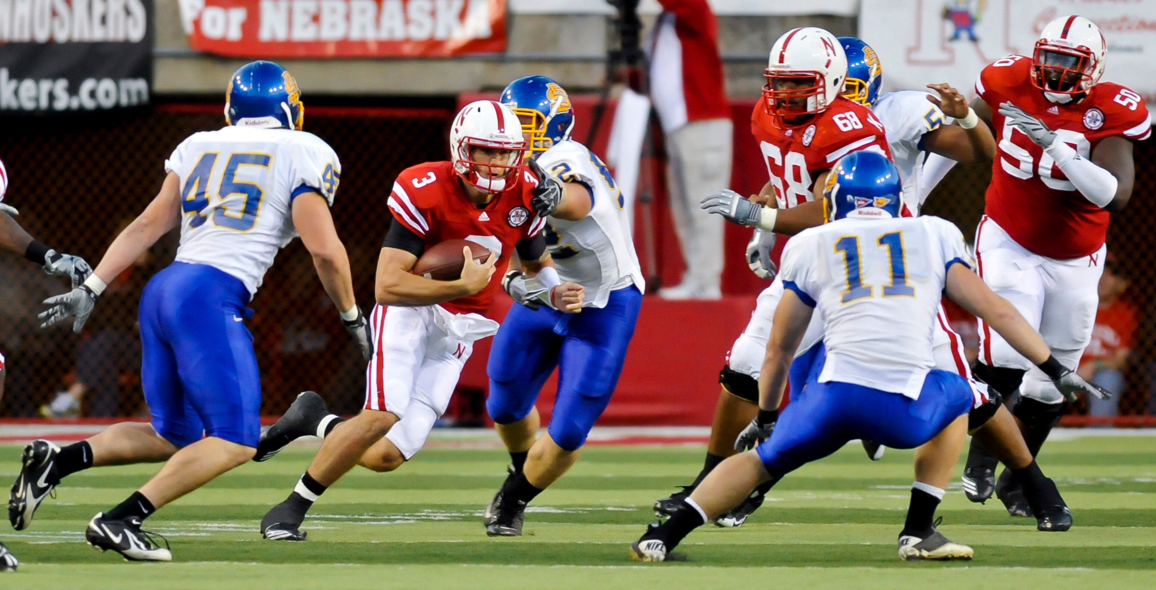LINCOLN, NEBRASKA - SEPTEMBER 25: Nebraska Cornhuskers quarterback Taylor Martinez #3, with the help of teammates offensive linesmen Keith Williams #68 and Mike Caputo #58 works his way through the South Dakota State Jackrabbit defense during their game a