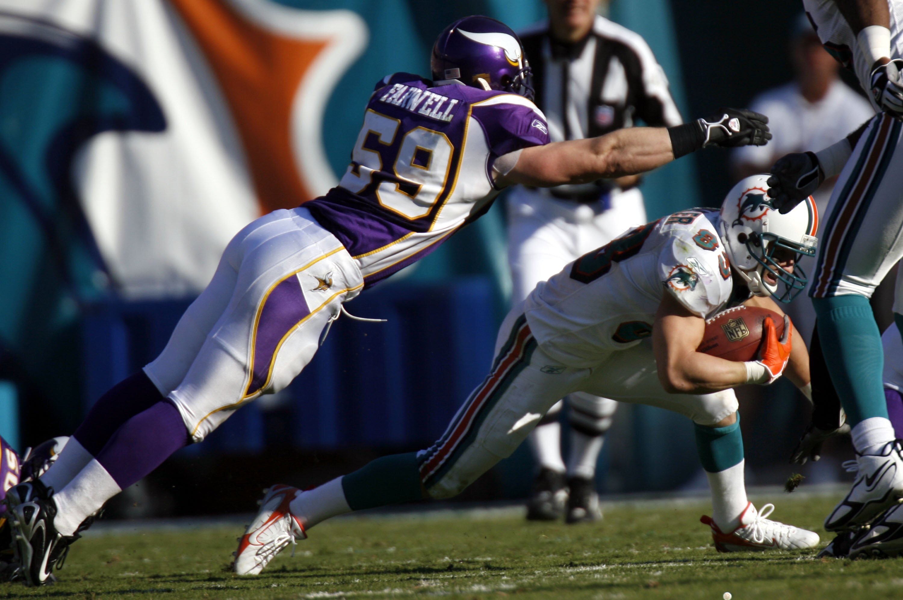 MIAMI - NOVEMBER 19:  Wide receiver Wes Welker #83 of the Miami Dolphins tries to evade Linebacker Heath Farwell #59 of the Minnesota Vikings in the fourth quarter at Miami Dolphin Stadium November 19, 2006 in Miami, Florida.  (Photo by Eliot J. Schechter