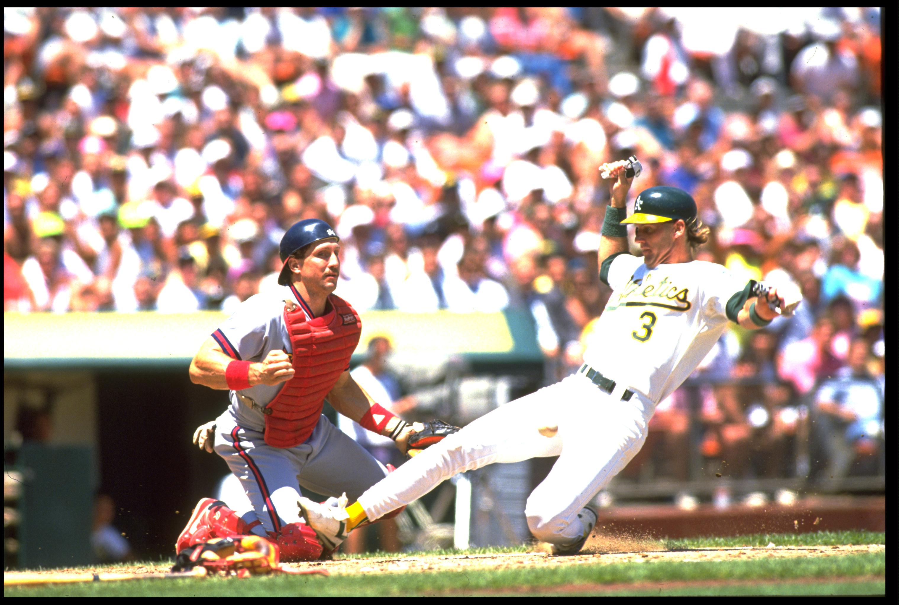 UNDATED:  JAMIE QUIRK, CATCHER FOR THE OAKLAND A''S, SLIDES ACROSS HOME PLATE AS LANCE PARRISH OF THE CALIFORNIA ANGELS IS UNABLE TO MAKE THE PLAY DURING THEIR GAME AT THE OAKLAND COLISEUM IN OAKLAND, CALIFORNIA.  MANDATORY CREDIT: OTTO GREULE/ALLSPORT.