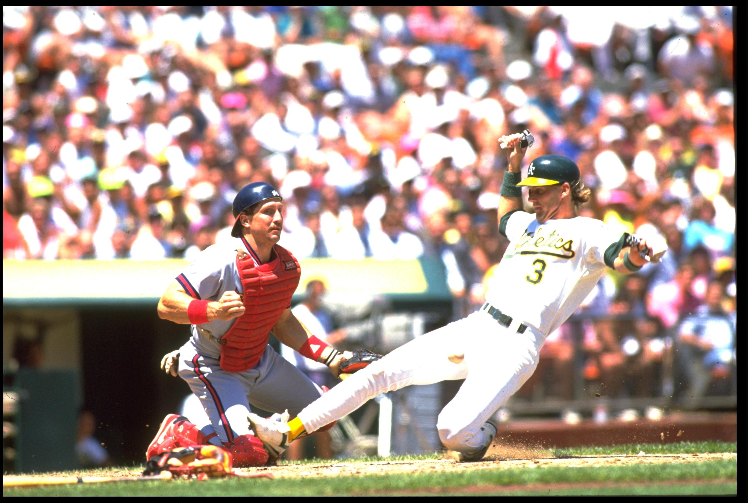 UNDATED:  JAMIE QUIRK, CATCHER FOR THE OAKLAND A''S, SLIDES ACROSS HOME PLATE AS LANCE PARRISH OF THE CALIFORNIA ANGELS IS UNABLE TO MAKE THE PLAY DURING THEIR GAME AT THE OAKLAND COLISEUM IN OAKLAND, CALIFORNIA.  MANDATORY CREDIT: OTTO GREULE/ALLSPORT.