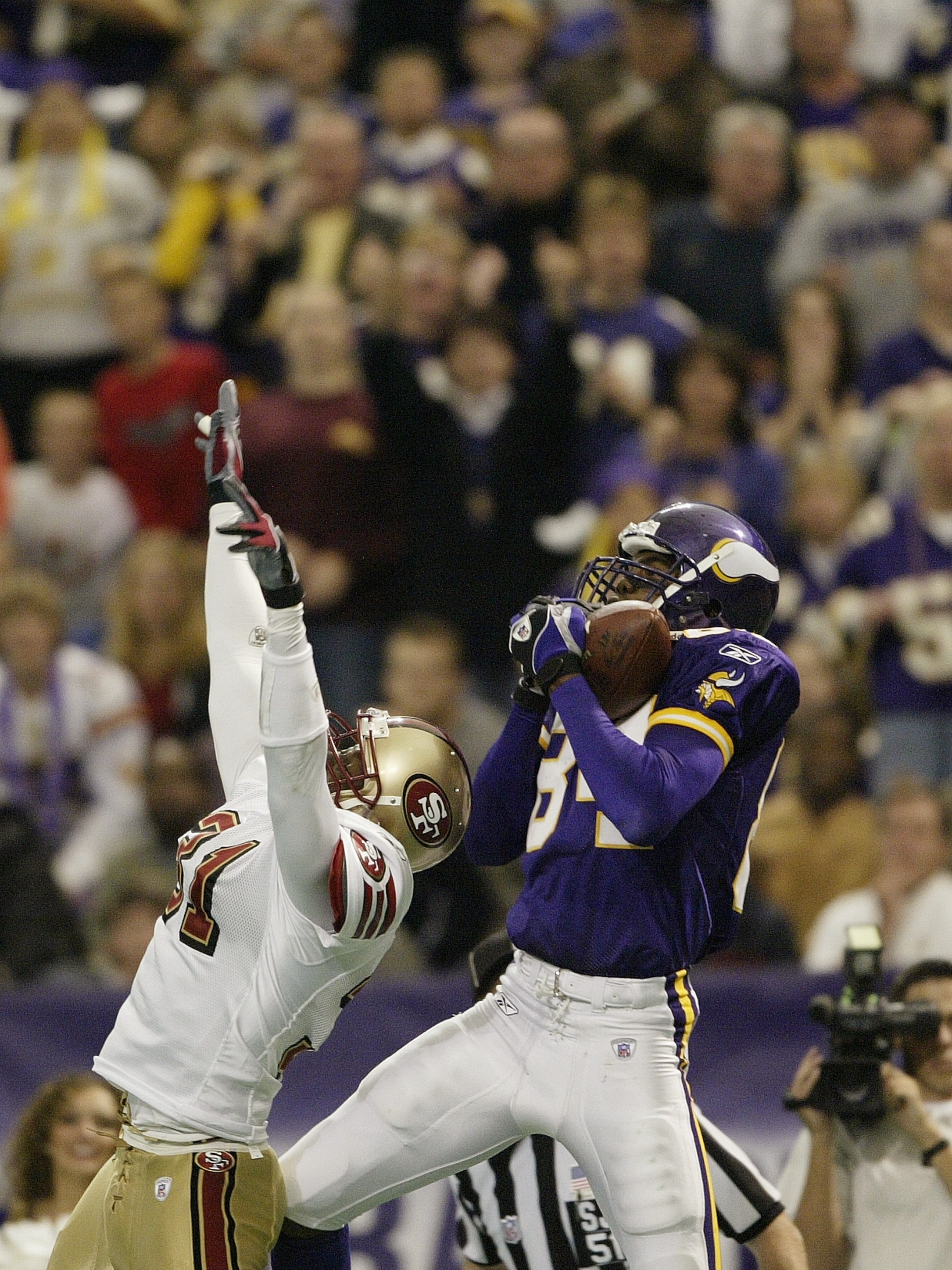 MINNEAPOLIS - SEPTEMBER 28:  Wide receiver Randy Moss #84 of the Minnesota Vikings makes the touchdown catch in the second quarter as safety Zack Bronson #31 of the San Francisco 49ers defends at the Hubert H. Humphrey Metrodome on September 28, 2003 in M