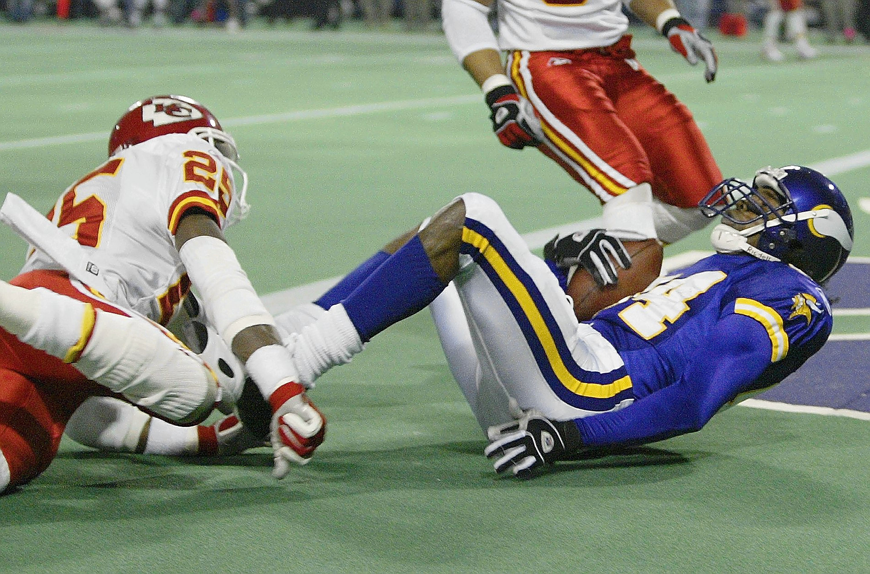 MINNEAPOLIS - DECEMBER 20:  Randy Moss #84 of the Minnesota Vikings falls into the endzone for a touchdown as Greg Wesley #25 of the Kansas City Chiefs defends on December 20, 2003 at the Hubert H. Humphrey Metrodome in Minneapolis, Minnesota.  (Photo by