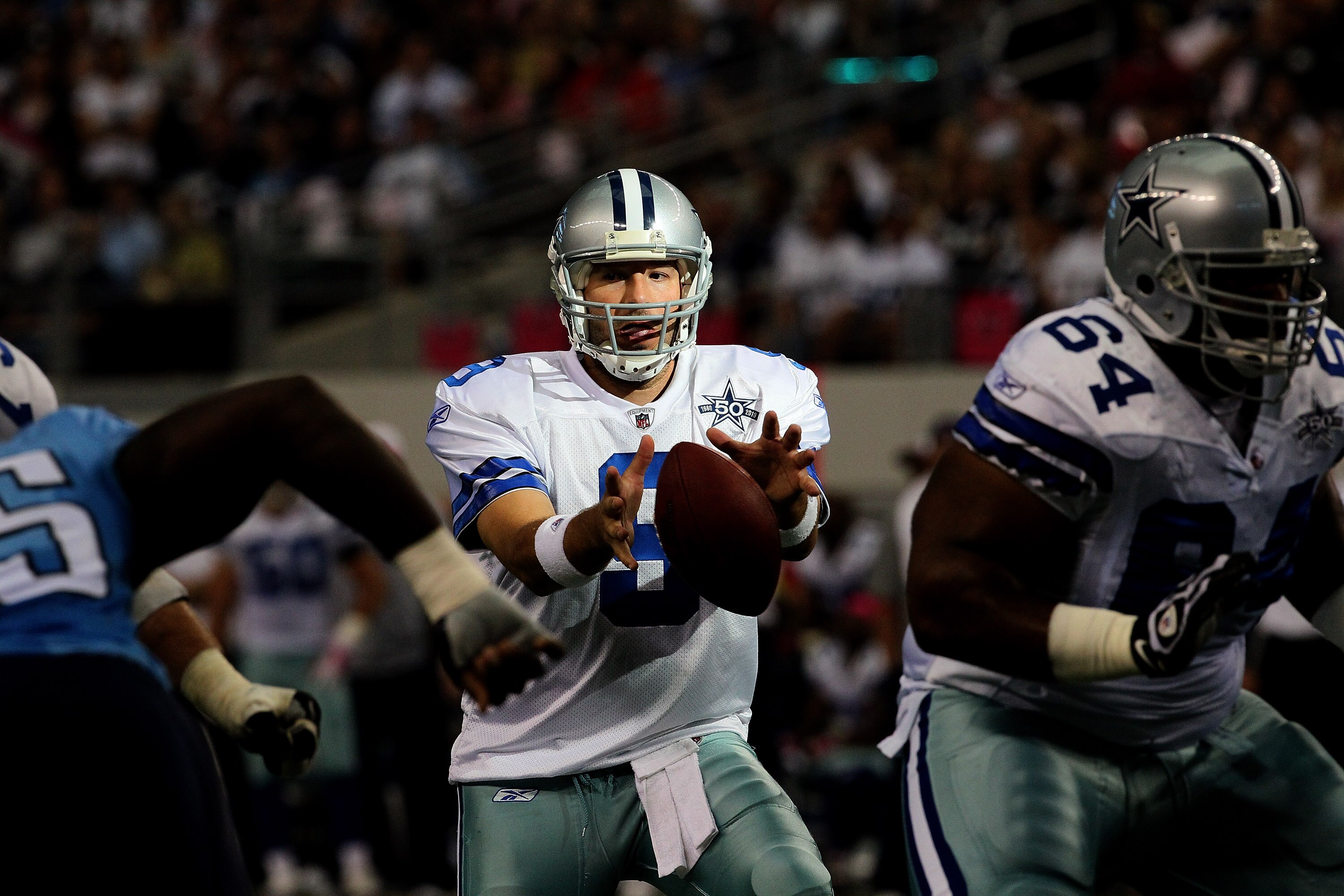 ARLINGTON, TX - OCTOBER 10:  Quarterback Tony Romo #9 of the Dallas Cowboys takes a snap against the Tennessee Titans at Cowboys Stadium on October 10, 2010 in Arlington, Texas.  (Photo by Stephen Dunn/Getty Images)