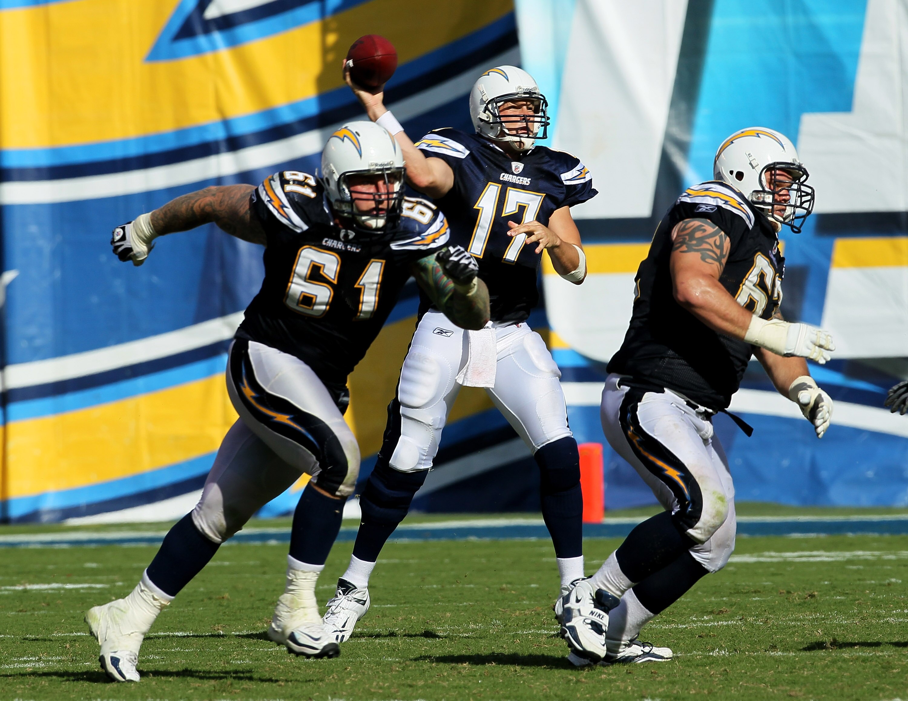 SAN DIEGO - OCTOBER 03:  Quarterback Philip Rivers of the San Diego Chargers throws a pass as center Nick Hardwick #61 and tackle Brandyn Dombrowski #62 block against the Arizona Cardinals at Qualcomm Stadium on October 3, 2010 in San Diego, California.