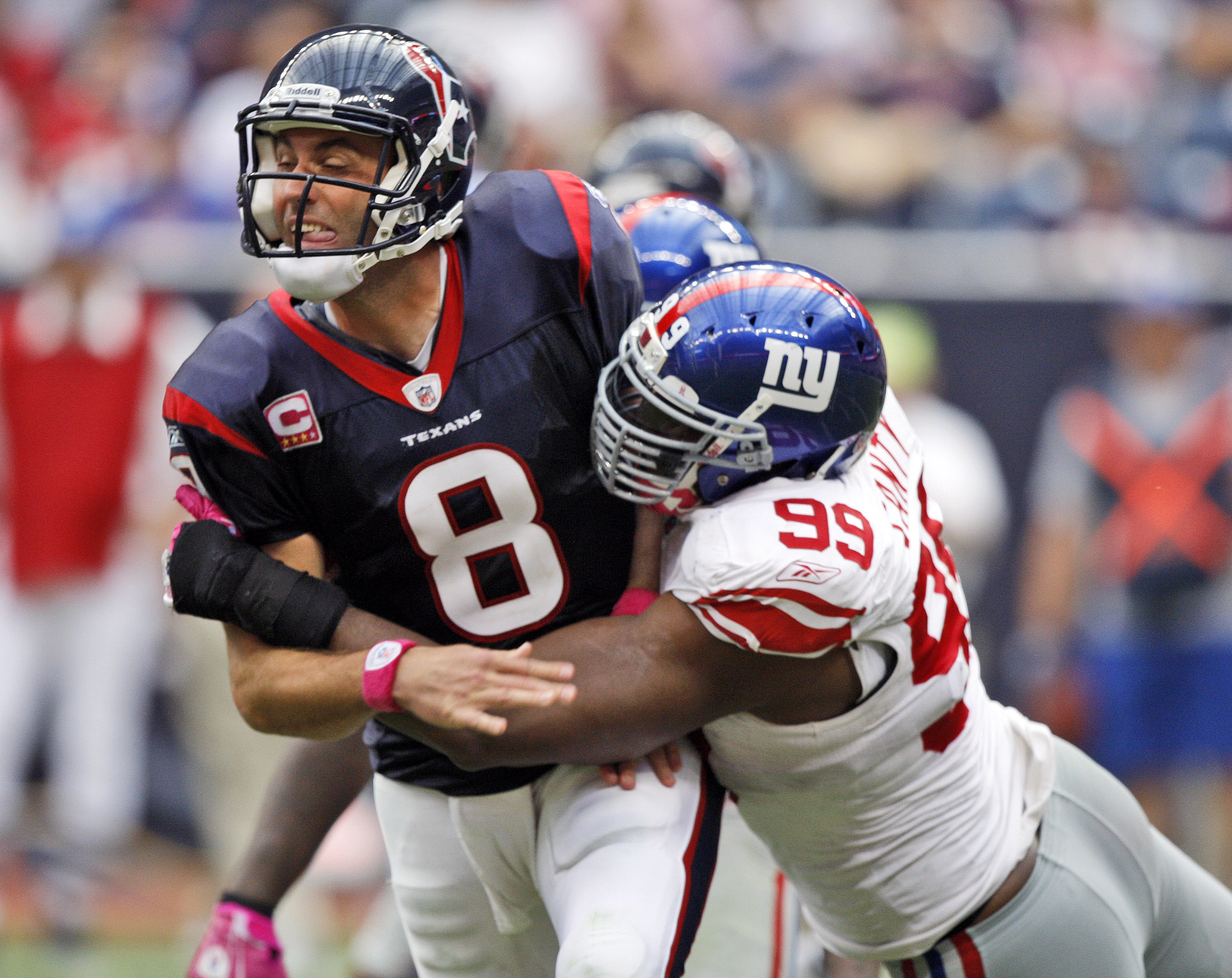 HOUSTON - OCTOBER 10:  Quarterback Matt Schaub #8 of the Houston Texans is hit by defensive tackle Chris Canty #99 of the New York Giants at Reliant Stadium on October 10, 2010 in Houston, Texas.  (Photo by Bob Levey/Getty Images)