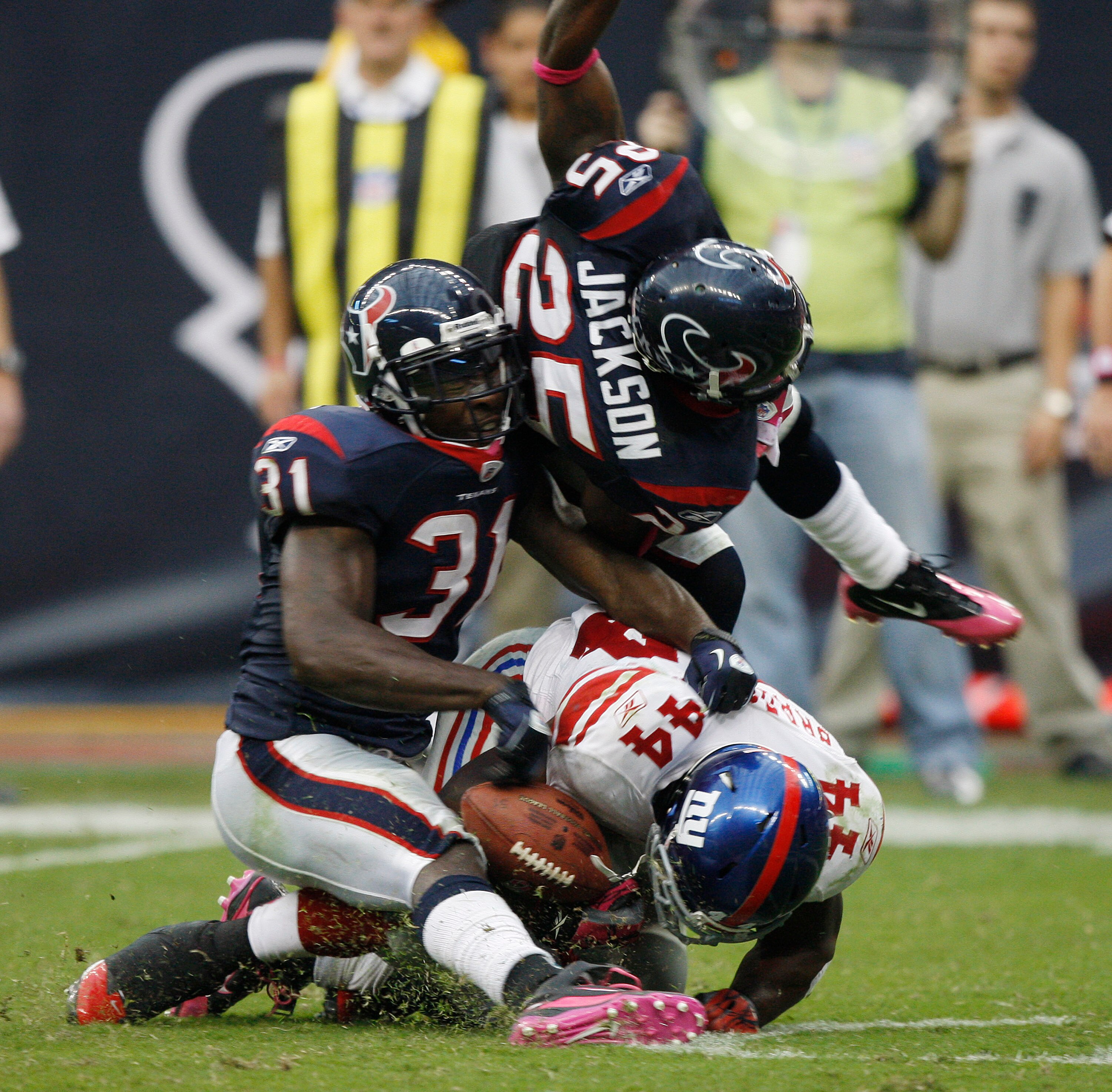 HOUSTON - OCTOBER 10:  Running back Ahmad Bradshaw #44 of the New York Giants takes a hard hit from strong safety Bernard Pollard #31 and cornerback Kareem Jackson #25 at Reliant Stadium on October 10, 2010 in Houston, Texas.  (Photo by Bob Levey/Getty Im