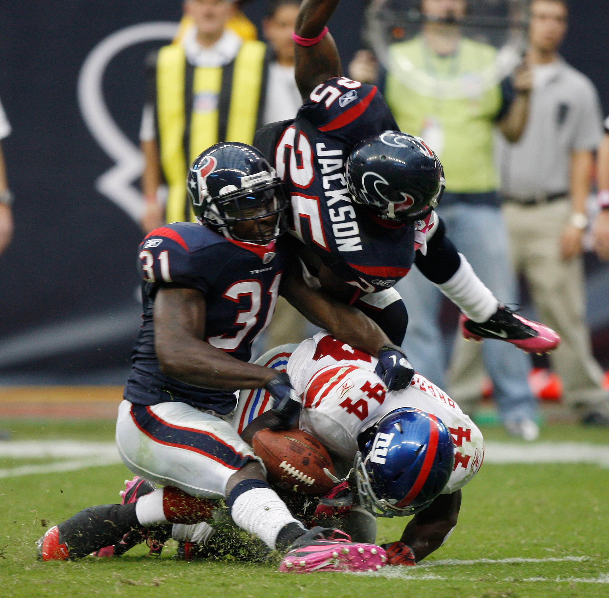 HOUSTON - OCTOBER 10:  Running back Ahmad Bradshaw #44 of the New York Giants takes a hard hit from strong safety Bernard Pollard #31 and cornerback Kareem Jackson #25 at Reliant Stadium on October 10, 2010 in Houston, Texas.  (Photo by Bob Levey/Getty Im