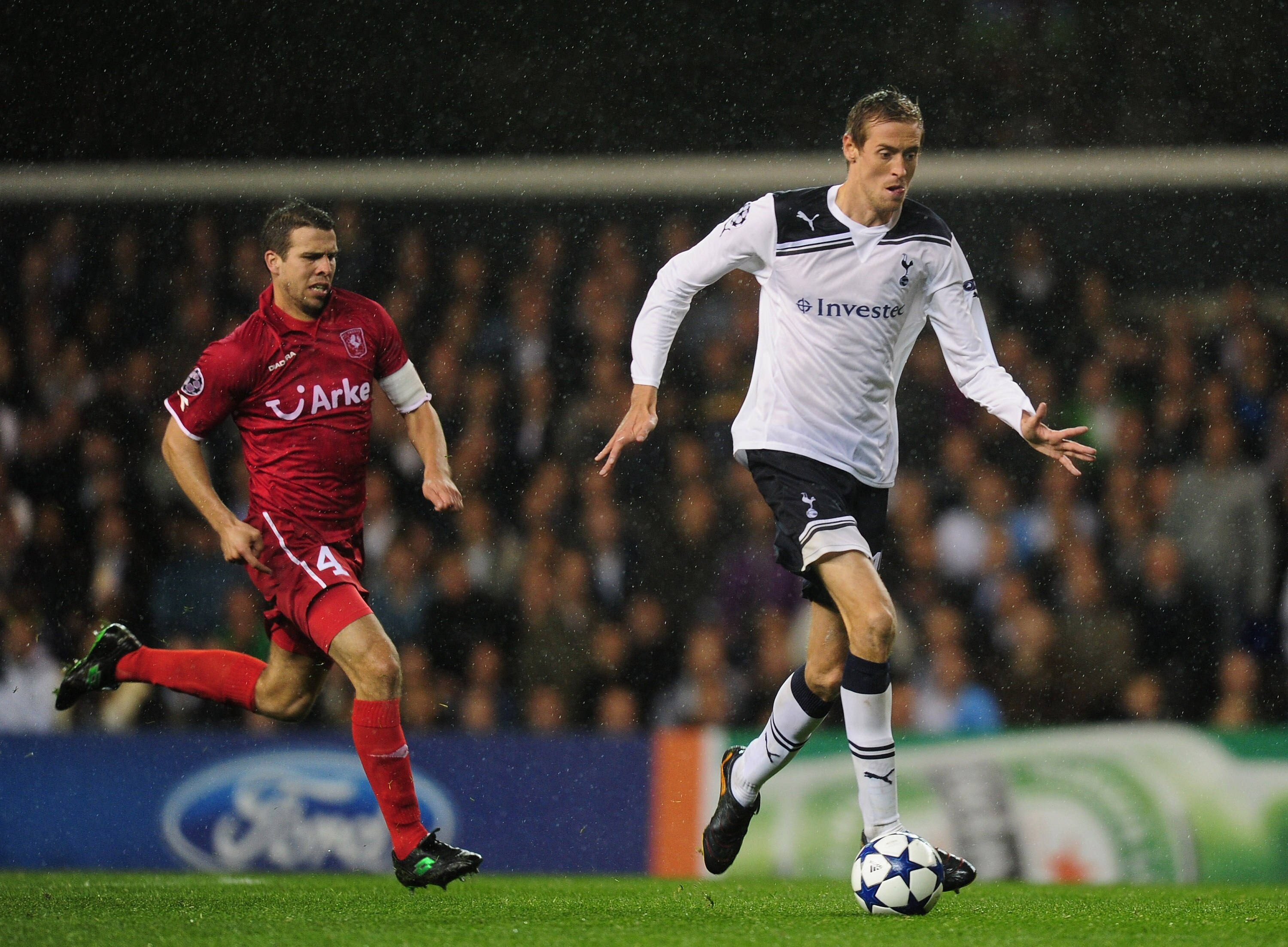 LONDON, ENGLAND - SEPTEMBER 29:  Peter Crouch of Tottenham is chased by Peter Wisgerhof of FC Twente looks on during the  UEFA Champions League Group A match between Tottenham Hotspur and FC Twente at White Hart Lane on September 29, 2010 in London, Engla