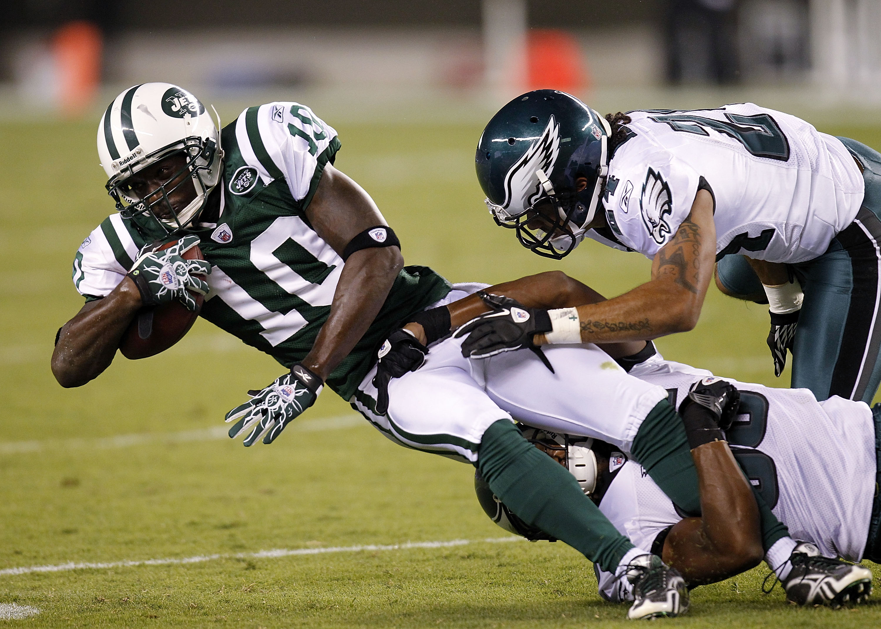 PHILADELPHIA - SEPTEMBER 02:  Trevard Lindley #35 and Macho Harris #24 of the Philadelphia Eagles take down Santonio Holmes #10 of the New York Jets in a preseason game at Lincoln Financial Field on September 2, 2010 in Philadelphia, Pennsylvania.  (Photo