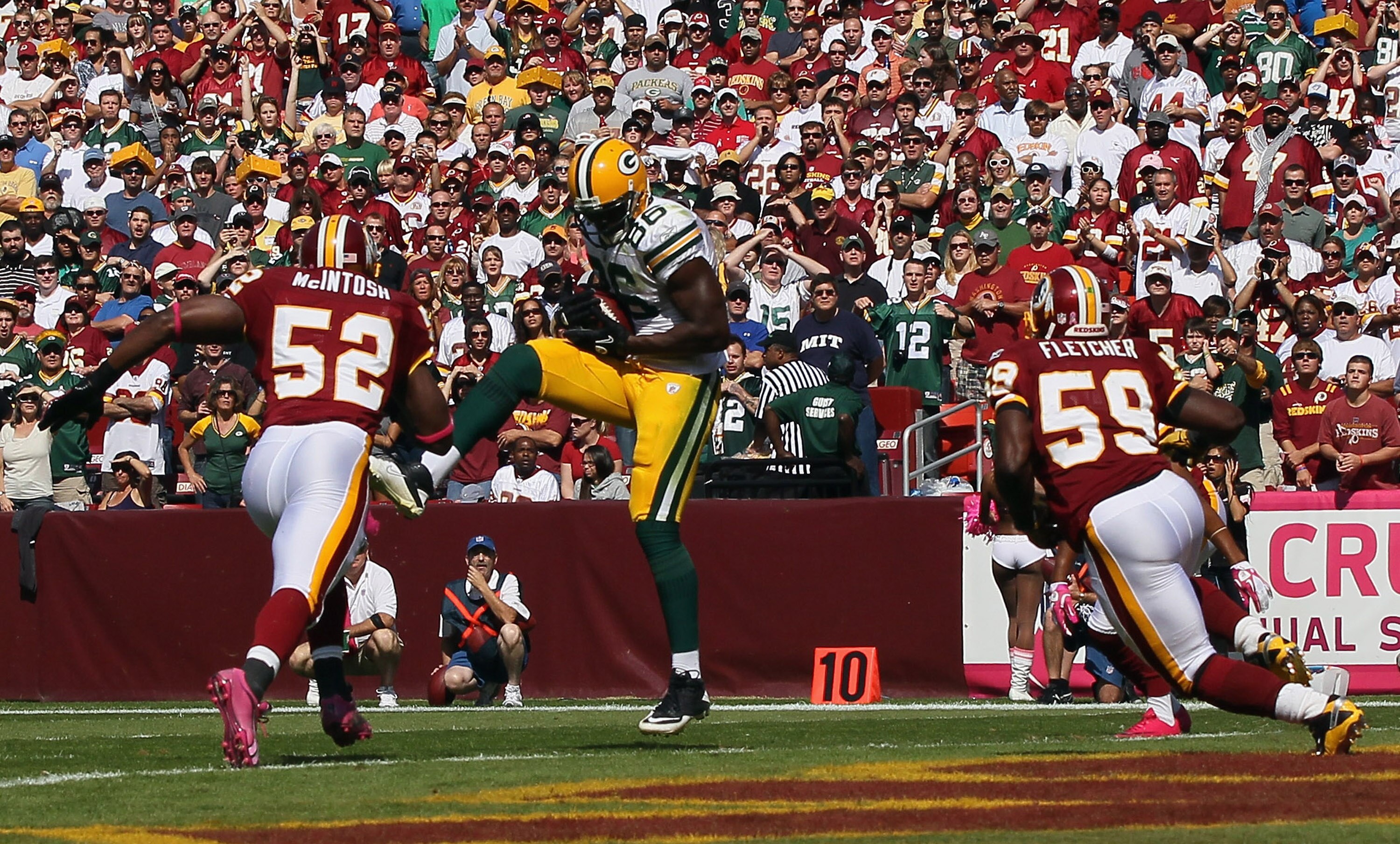 LANDOVER, MD - OCTOBER 10: Tight end Donald Lee #86 of the Green Bay Packers catches a touchdown pass as Rocky McIntosh #52 and London Fletcher #59 of the Washington Redskins try to defend the pass at FedExField on October 10, 2010 in Landover, Maryland.