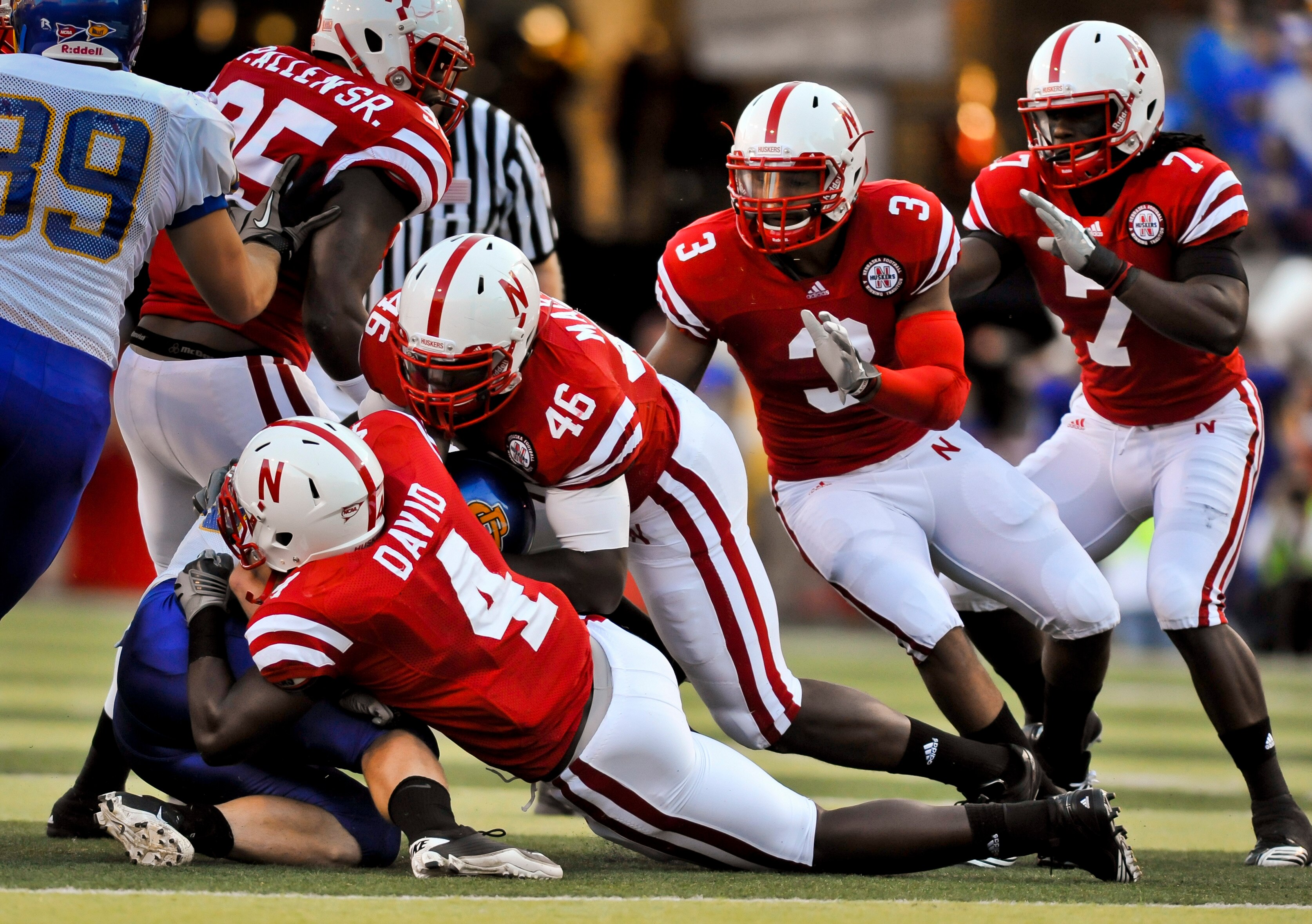 LINCOLN, NEBRASKA - SEPTEMBER 25: Nebraska Cornhuskers linebacker Lavonte David #4, linebacker Eric Martin #46, safety Rickey Thenarse #3, defensive back DeJon Gomes #7 bring down South Dakota State Jackrabbits running back Kyle Minett #30 during first ha