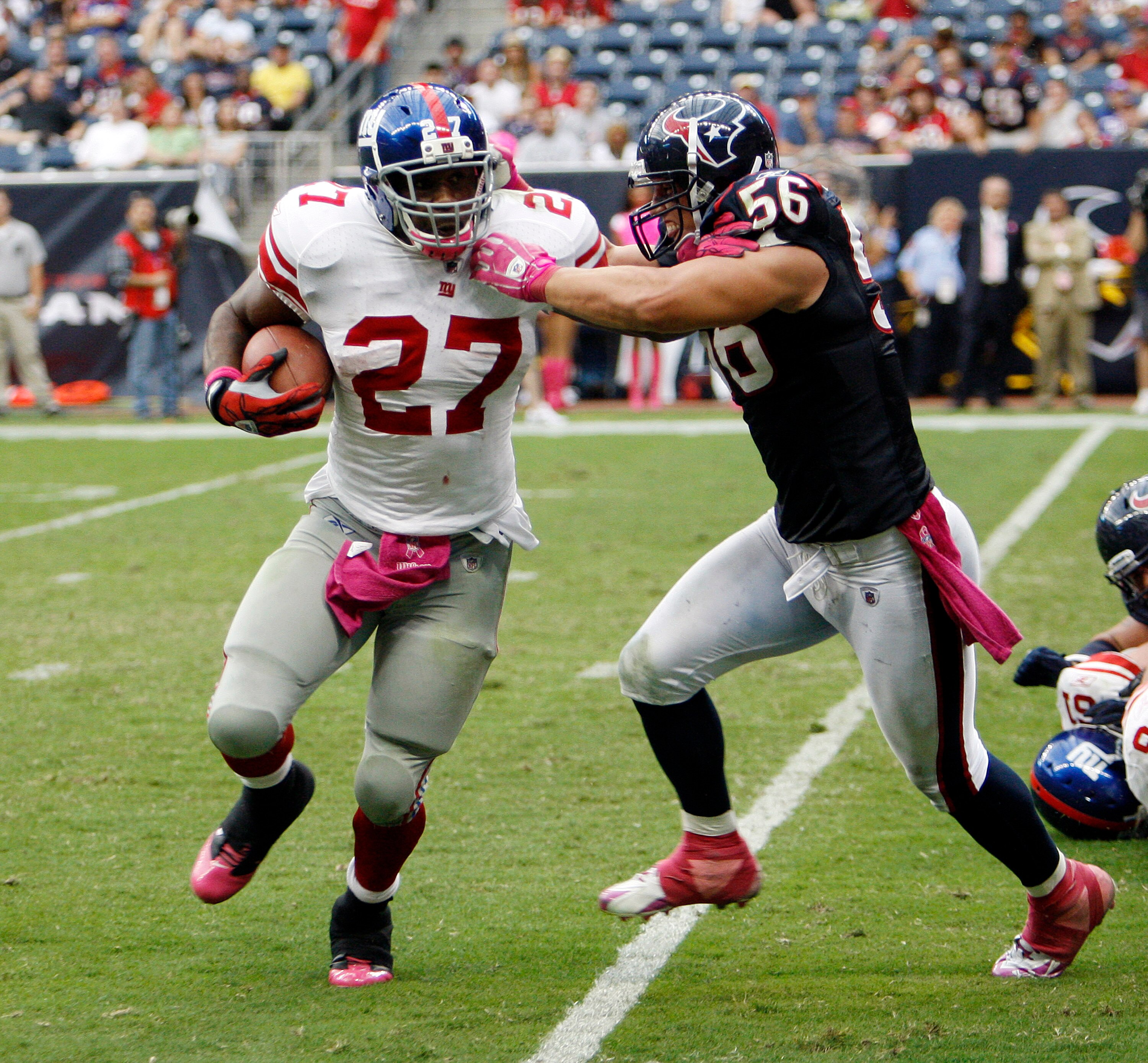 HOUSTON - OCTOBER 10:  Running back Brandon Jacobs #27 of the New York Giants eludes the tackle of linebacker  Brian Cushing #56 of the Houston Texans at Reliant Stadium on October 10, 2010 in Houston, Texas. New York won 34-10.  (Photo by Bob Levey/Getty