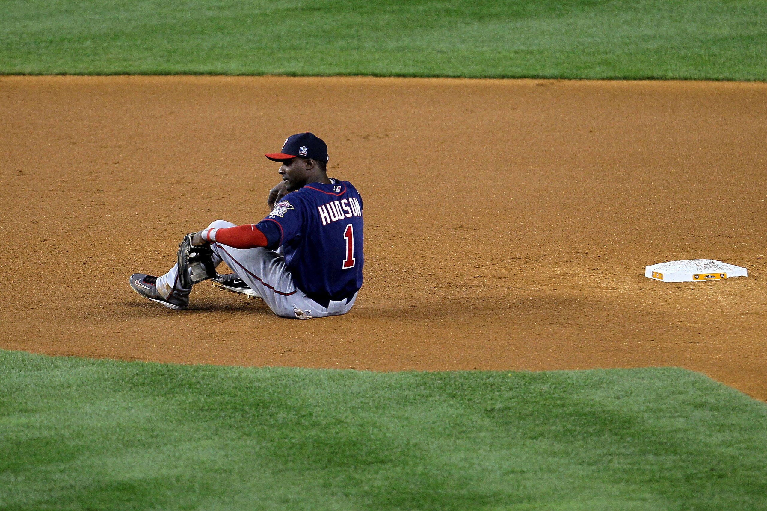 NEW YORK - OCTOBER 09:  Orlando Hudson #1 of the Minnesota Twins sits on the infield dirt in the bottom of the fourth inning after Curtis Granderson #14 the New York Yankees advanced to third base after stealing second during Game Three of the ALDS part o