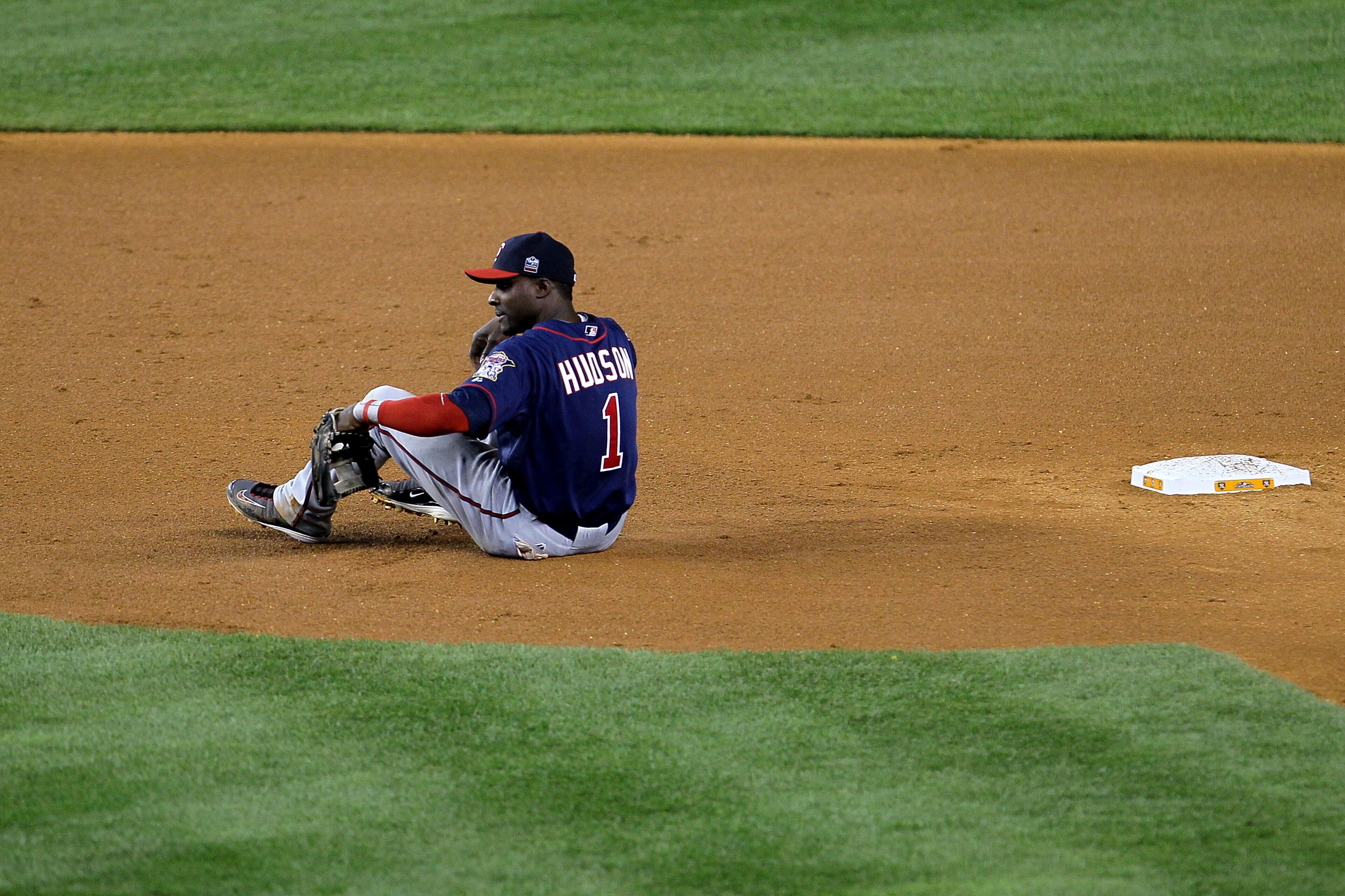NEW YORK - OCTOBER 09:  Orlando Hudson #1 of the Minnesota Twins sits on the infield dirt in the bottom of the fourth inning after Curtis Granderson #14 the New York Yankees advanced to third base after stealing second during Game Three of the ALDS part o
