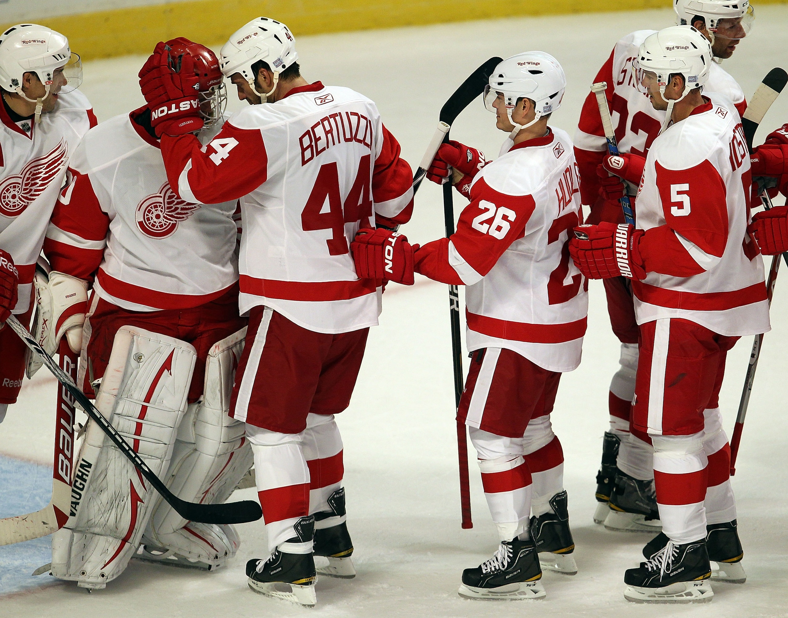 CHICAGO - OCTOBER 09: Chris Osgood #30 of the Detroit Red Wings is congratulated by teammates Todd Bertuzzi #44, Jiri Hudler #26 and Nicklas Lidstrom #5 after a win over the Chicago  Blackhawks at the United Center on October 9, 2010 in Chicago, Illinois.