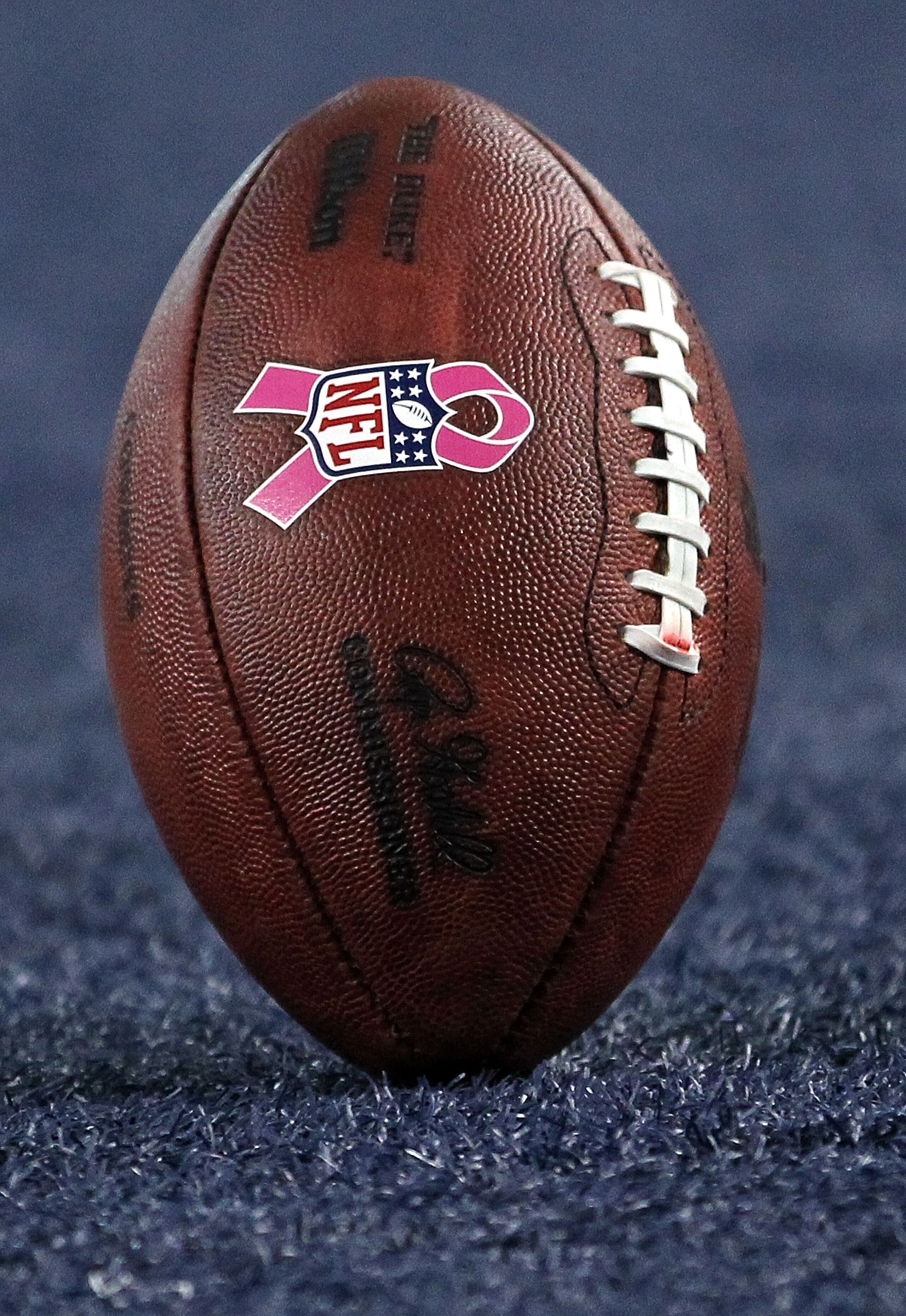 ARLINGTON, TX - OCTOBER 10: An NFL logo with a pink ribbon for Breast Cancer Awareness month on a football between the Tennessee Titans and the Dallas Cowboys at Cowboys Stadium on October 10, 2010 in Arlington, Texas. (Photo by Ronald Martinez/Getty Im ARLINGTON, TX - OCTOBER 10: An NFL logo with a pink ribbon for Breast Cancer Awareness month on a football between the Tennessee Titans and the Dallas Cowboys at Cowboys Stadium on October 10, 2010 in Arlington, Texas. (Photo by Ronald Martinez/Getty Im
