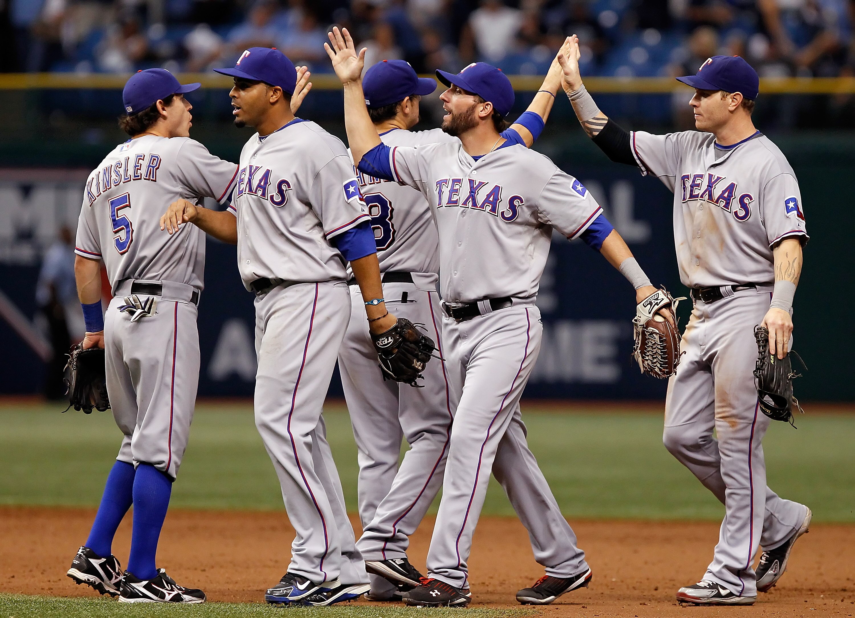 ST. PETERSBURG - OCTOBER 06:  Outfielder Nelson Cruz #17 (2L), Jeff Francoeur #21 and Josh Hamilton #32 of the Texas Rangers celebrate their team's victory over the Tampa Bay Rays during Game 1 of the ALDS at Tropicana Field on October 6, 2010 in St. Pete