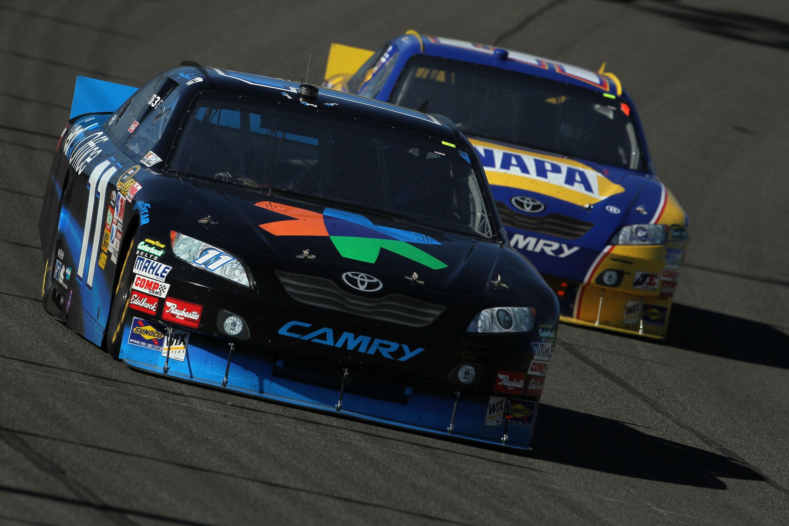 FONTANA, CA - OCTOBER 10:  Denny Hamlin, driver of the #11 FedEx Office Toyota, leads Martin Truex Jr., driver of the #56 NAPA Toyota, during the NASCAR Sprint Cup Series Pepsi Max 400 on October 10, 2010 in Fontana, California.  (Photo by Jeff Gross/Gett